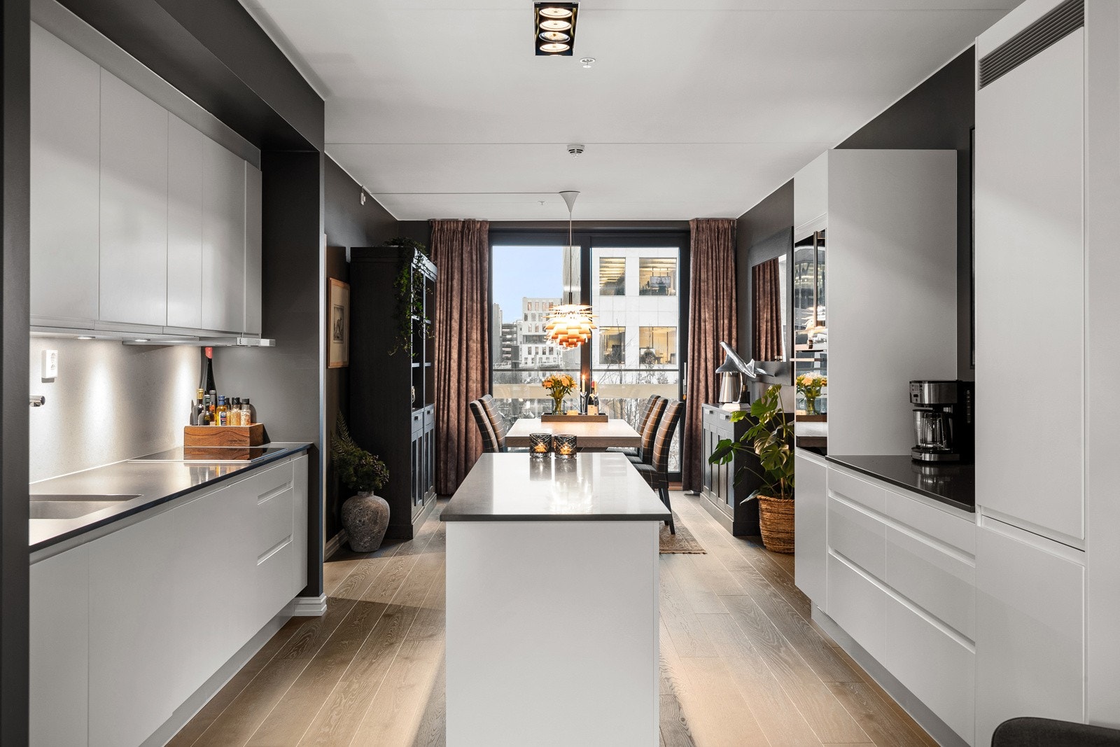 Innredningen har hvite glatte fronter og påkostet benkeplate av kvarts med underlimt oppvaskkum. Praktisk med takhøye overskap med belysning under på den ene siden. Galleribilde