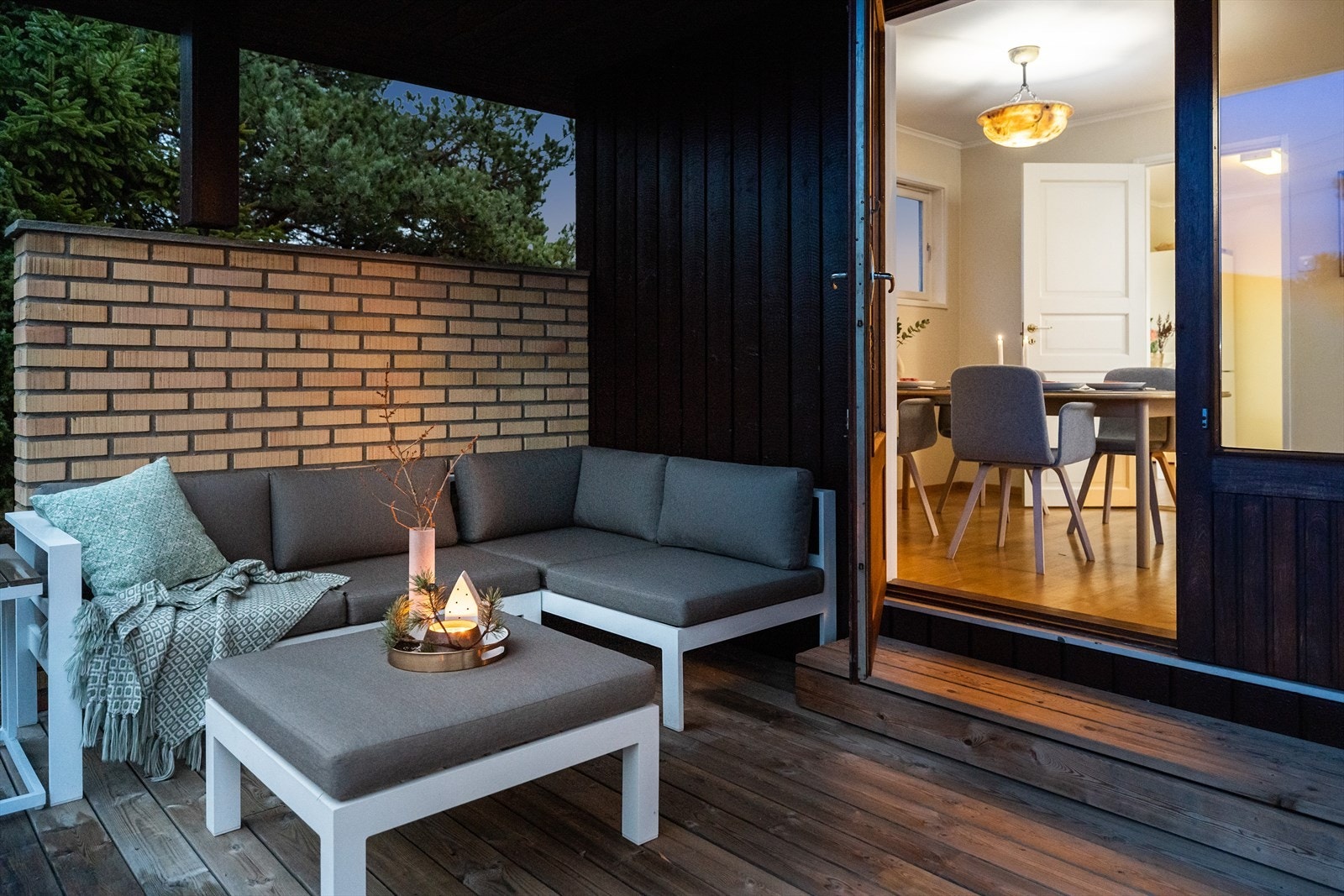 På den høytliggende vestsiden av huset finner man en romslig terrasse, formskåret og tilpasset landskapet - delvis overbygd. Halvmur i tegl som levegg. Galleribilde