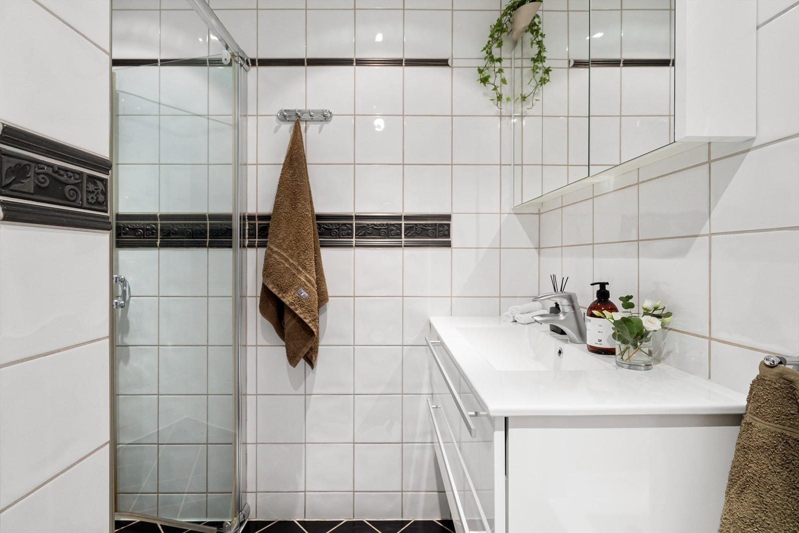 Flott og lyst fliaslagt baderom med gulvvarme og innfelt downlights i himling. Her står flisene på badet i stil med det klassiske i leiligheten. Galleribilde