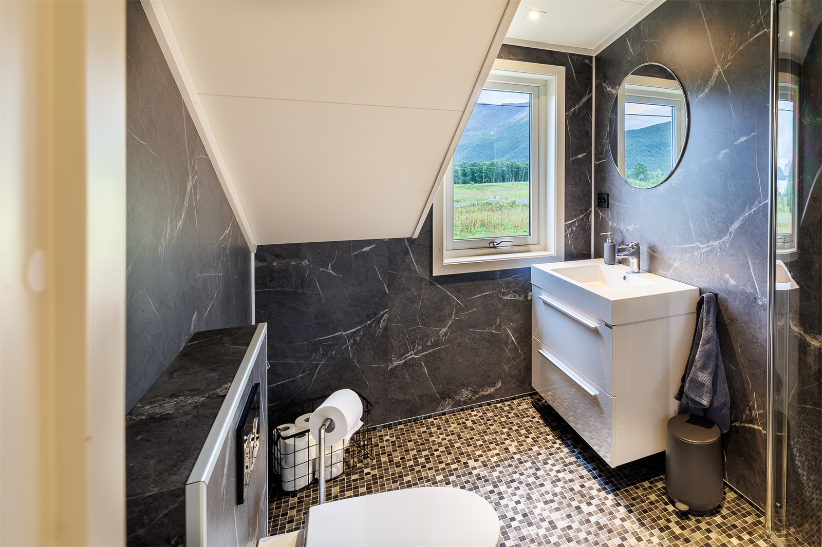 Badet inneholder toalett og dusjhjørne med glassdører. Galleribilde