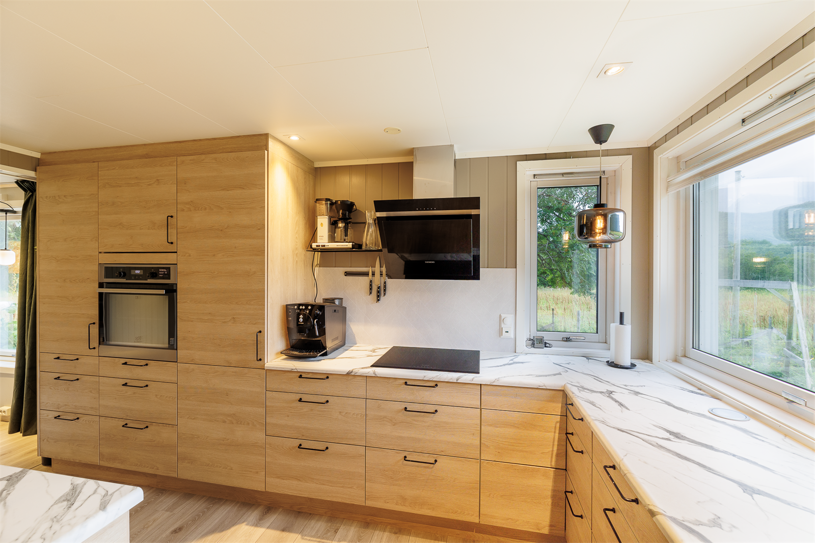 Mange vindusflater og spotter gir rikelig med lys på kjøkkenet. Galleribilde