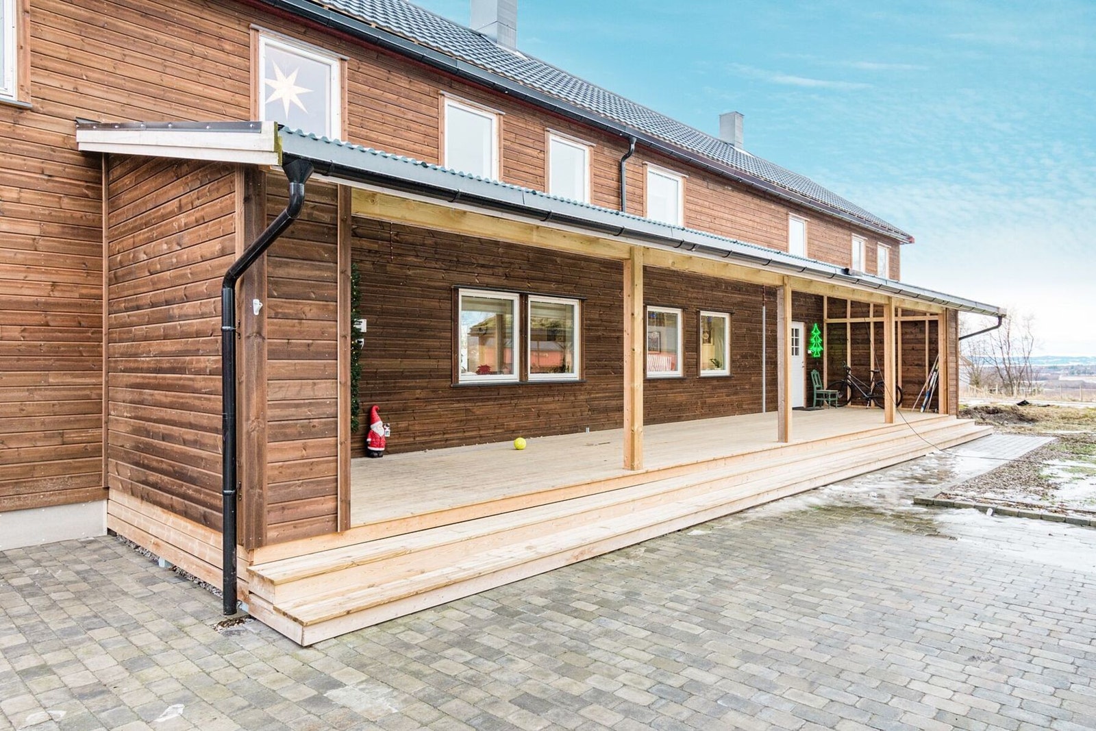 Tunsiden av våningshuset med nye plattinger og takoverbygg. Galleribilde