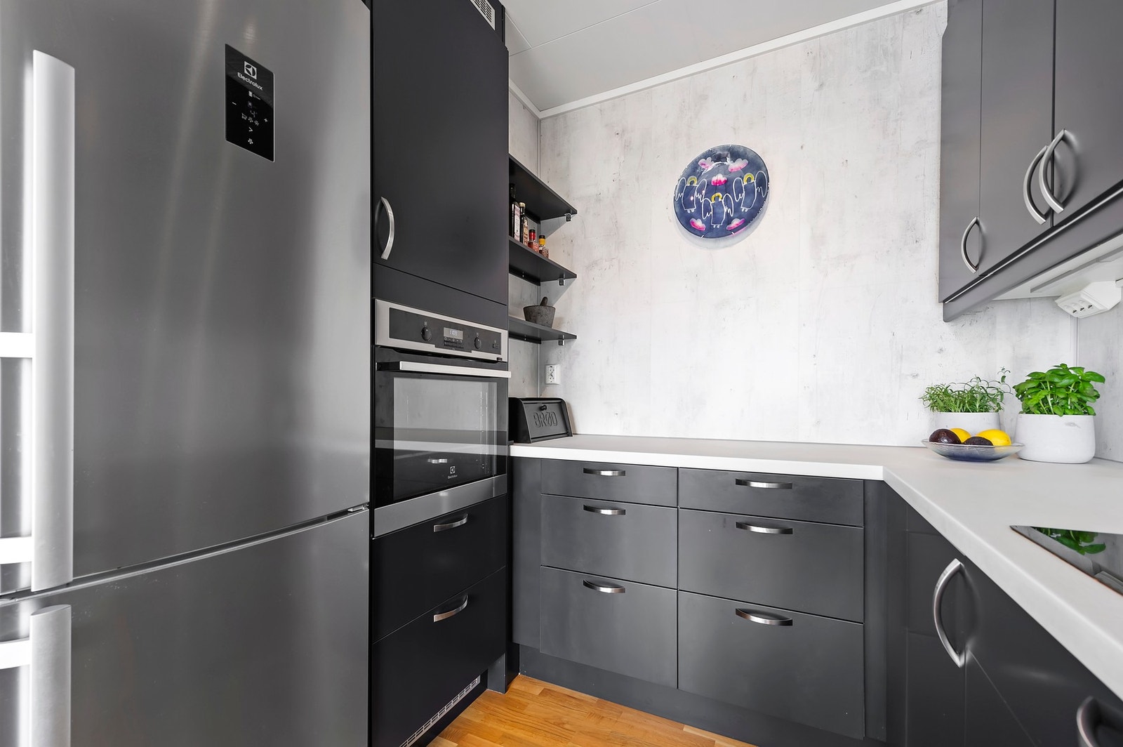 Kjøkken har parkett på gulv og malt tapet på vegger med kitchenboard mellom benkeskap og overskap Galleribilde