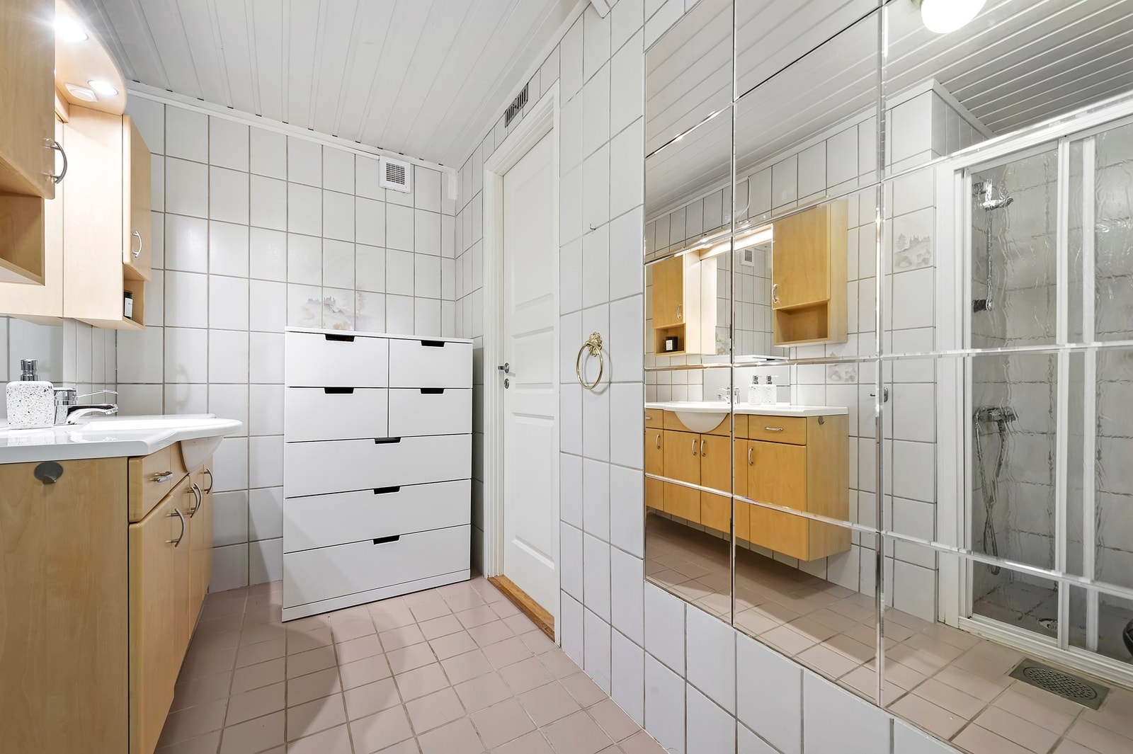 Bad har flis på vegger og flislagt gulv med varmekabler. Toalett, nedfelt servant og dusjnisje Galleribilde