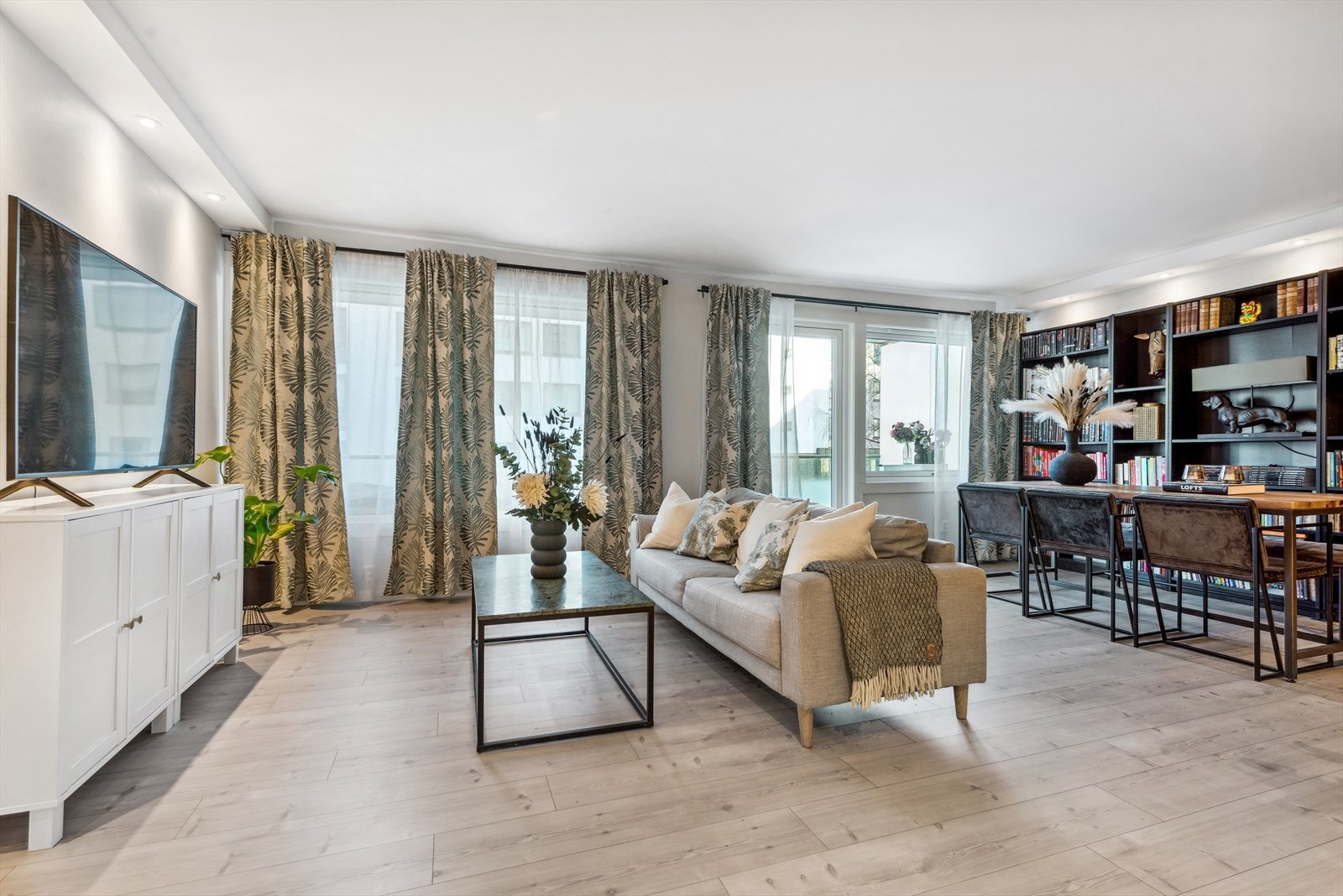 Luftig stue med store lysgivende vindusflater og utgang til balkong Galleribilde