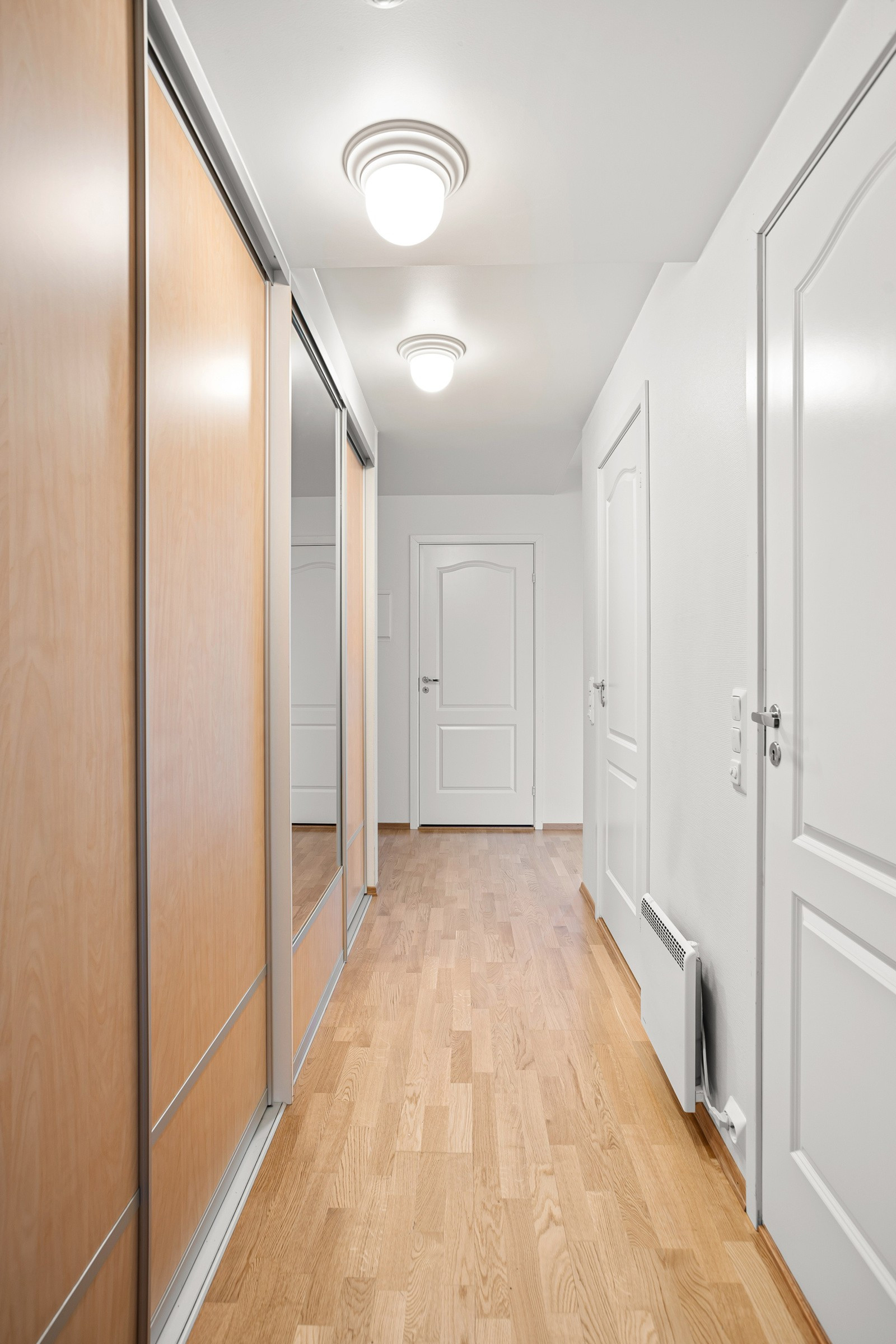 Romslig gang med gode oppbevaringsmuligheter i lekker skyvedørsgarderobe!