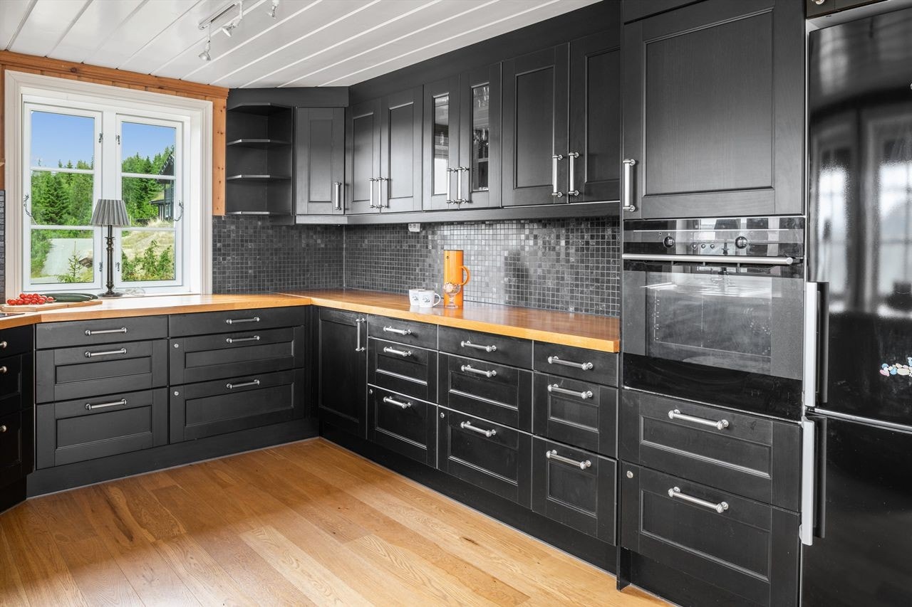 Smakfull kjøkkeninnredning med raus skapplass Galleribilde