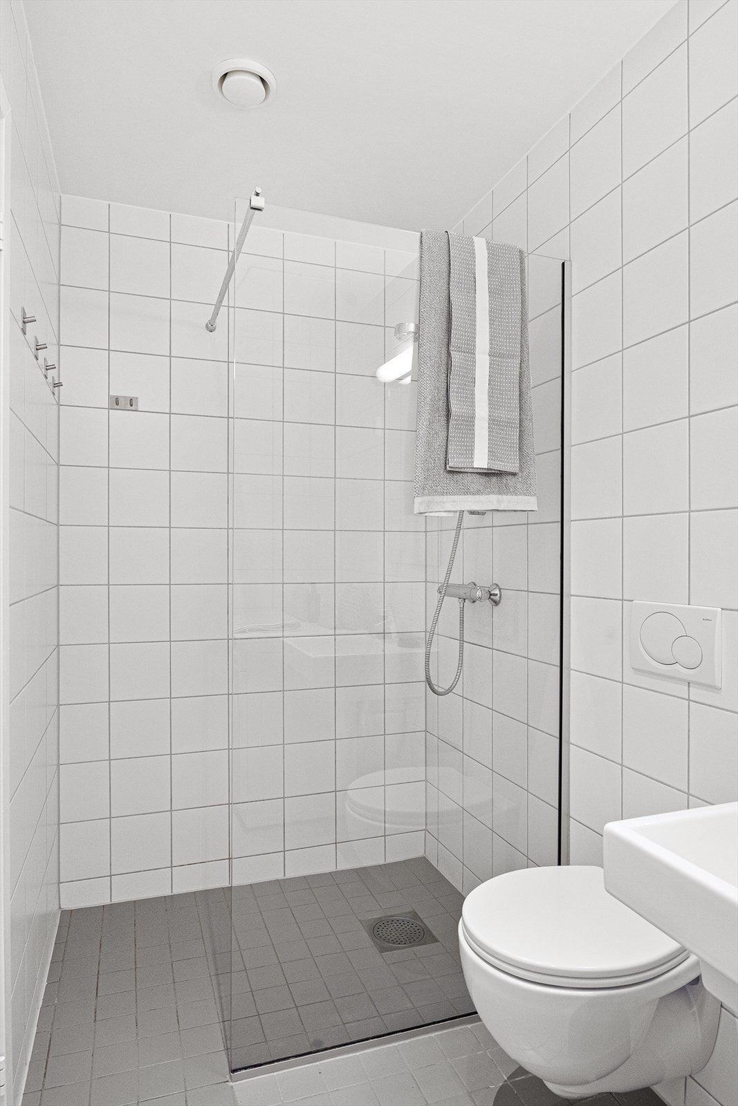 Badet har utstyr og garnityr som består av servantinnredning med keramisk servant, speil, veggmontert toalett og dusjhjørne med fastmontert glass som skillevegg. Det er opplegg for vaskemaskin Galleribilde