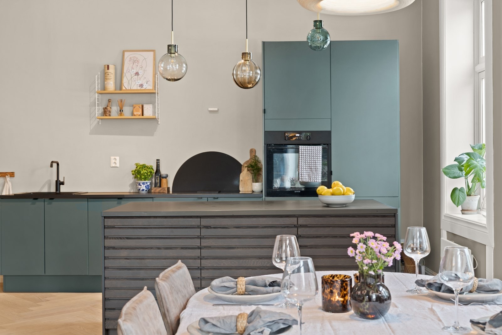 Spiseplassen er i direkte tilknytning til kjøkkenet som bidrar til sosiale soner selv ved matlaging Galleribilde