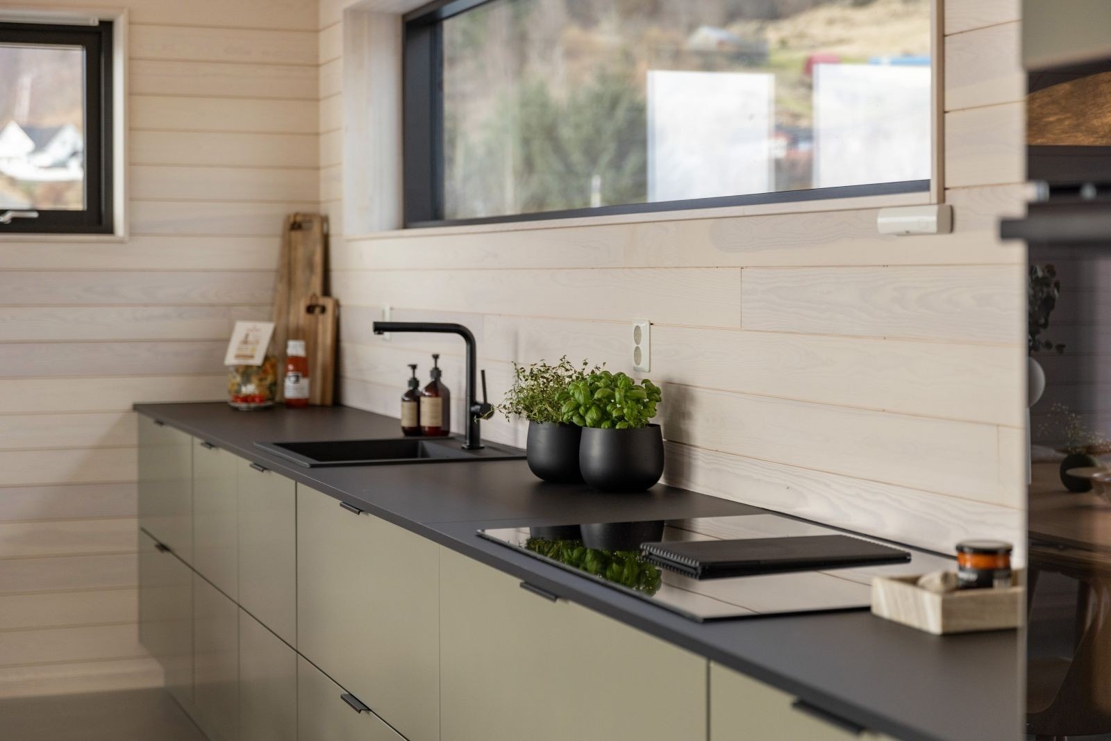 Lekkert kjøkken fra Strai med slette grønne fronter med benkeplate i kompaktlaminat Galleribilde