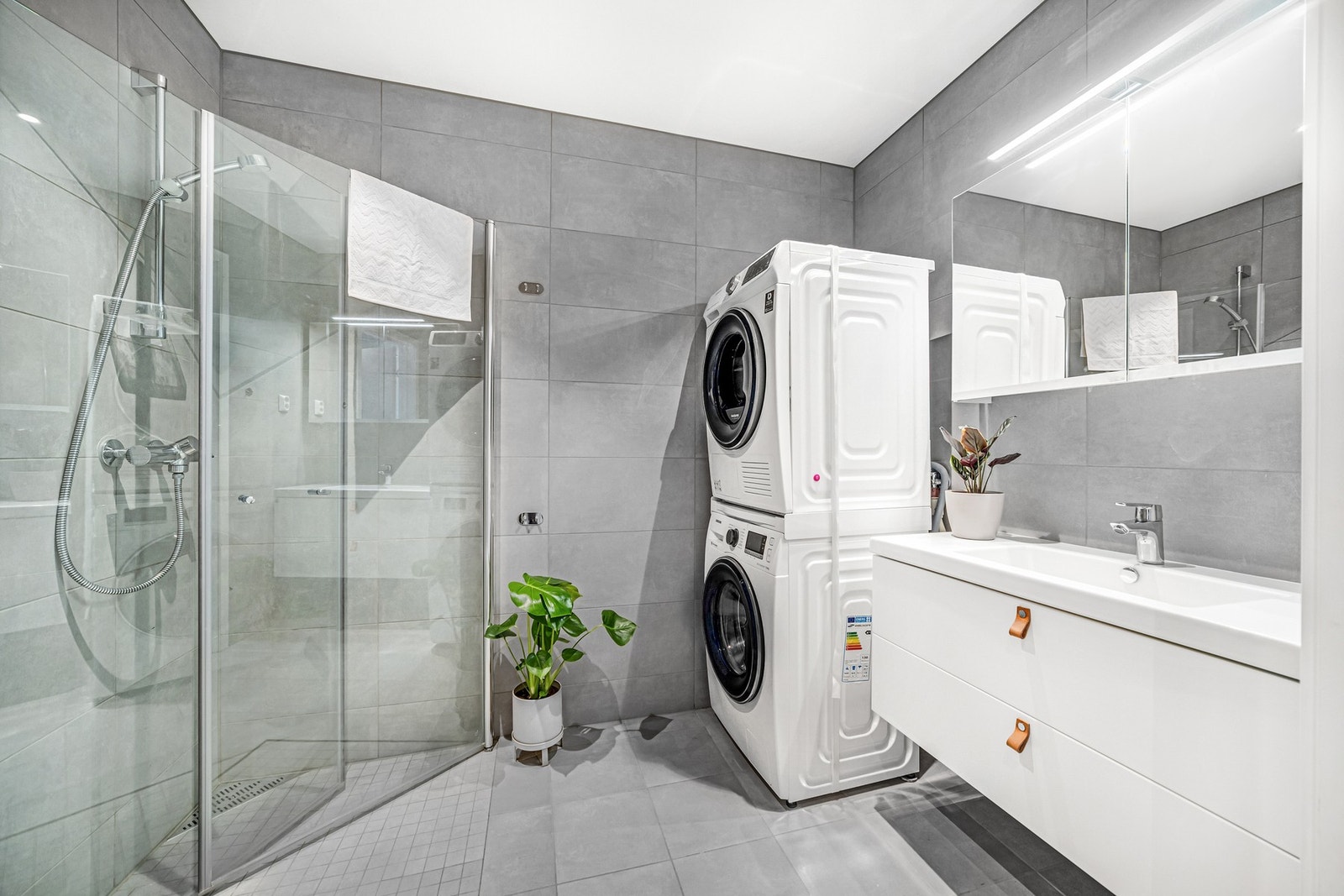 Lekkert bad med oppgraderinger som baderomsinnredning m/skuffer, fliser og vegghengt toalett. Opplegg for vaskemaskin. Galleribilde