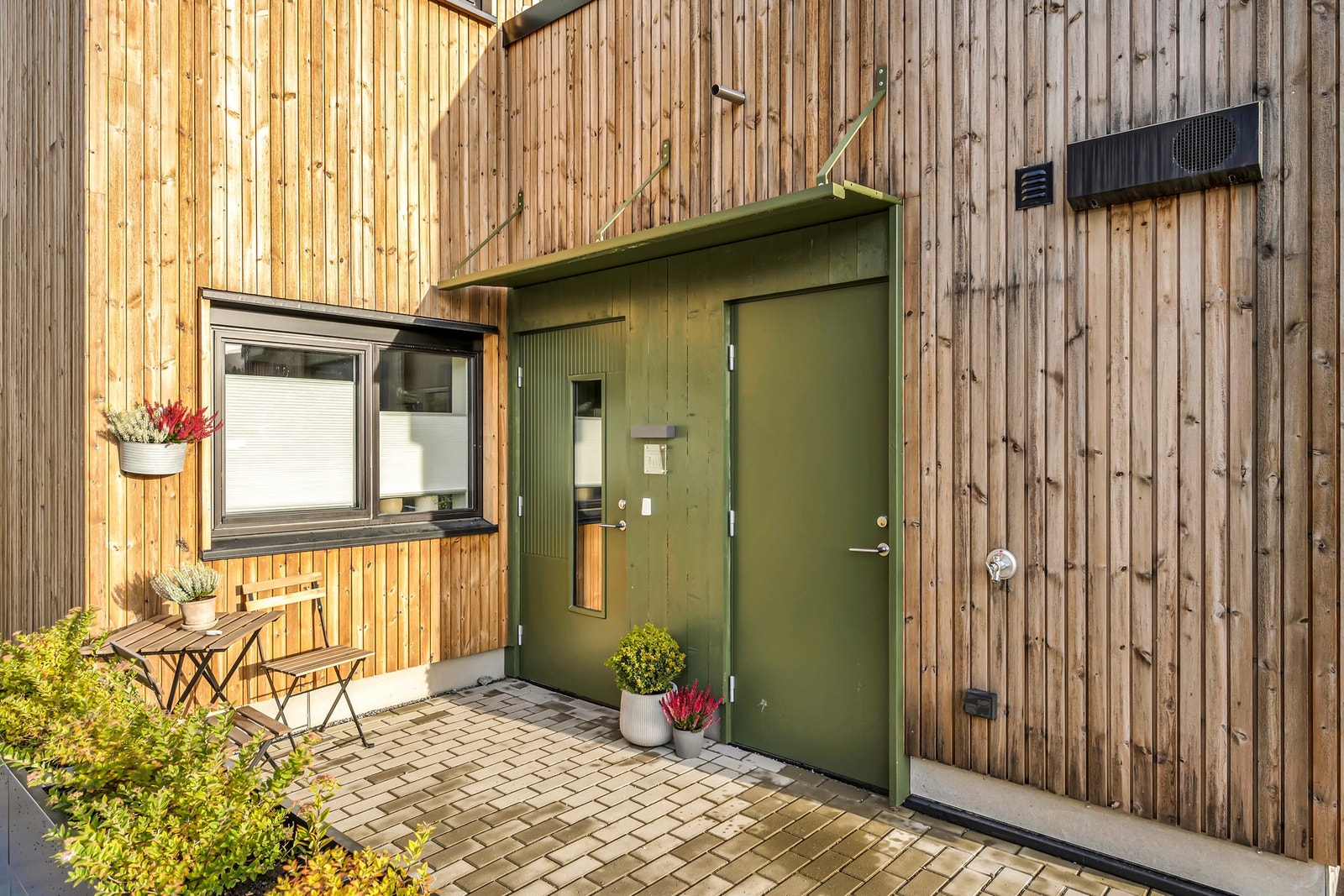 Inngangsparti hvor man kan sitte i solveggen og nyte en kaffekopp. Galleribilde