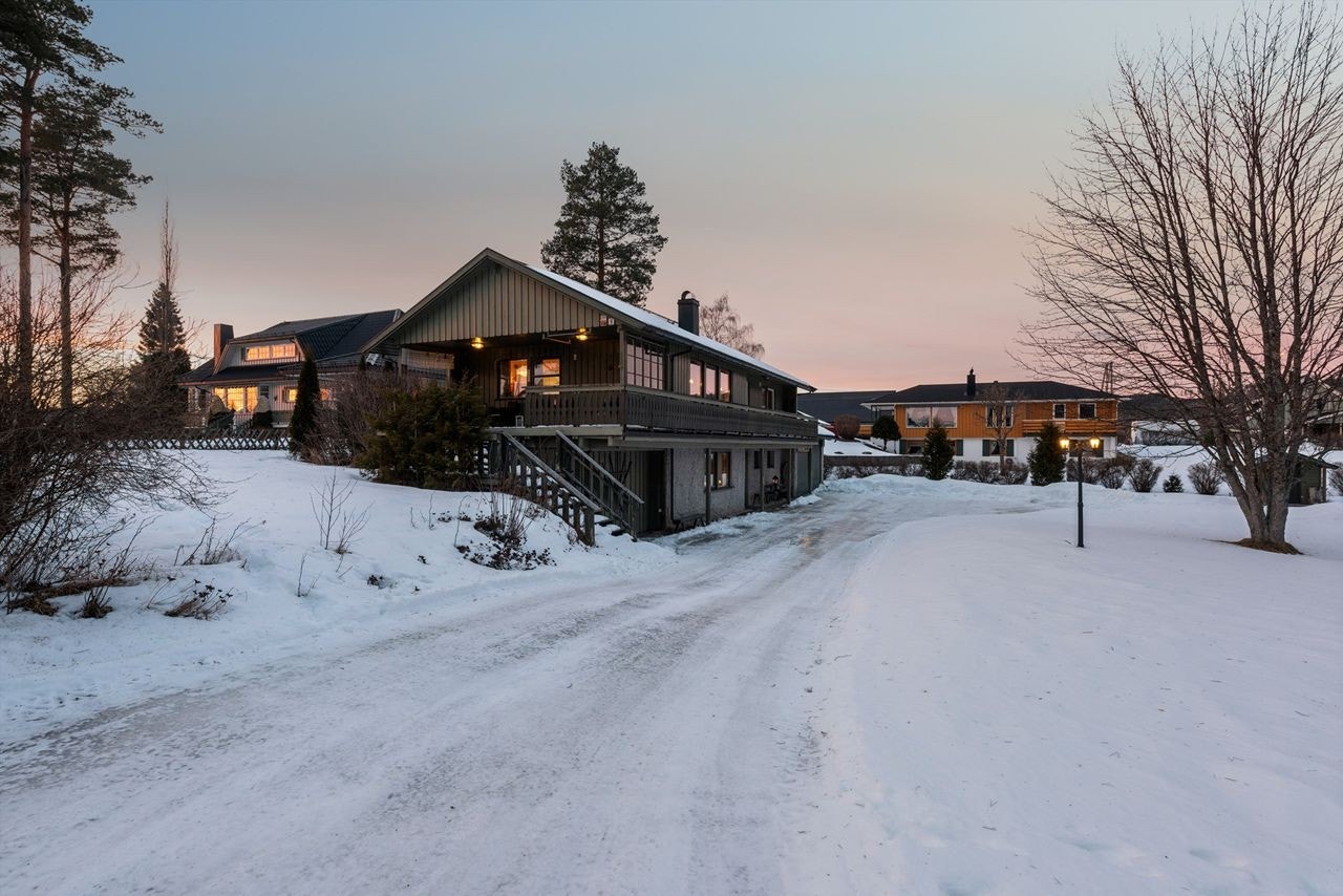 Boligen står på en flat og romslig tomt, med asfaltert gårdsplass. Her kan du parkere i dobbelgarasje, eller på egen biloppstillingsplass. Galleribilde