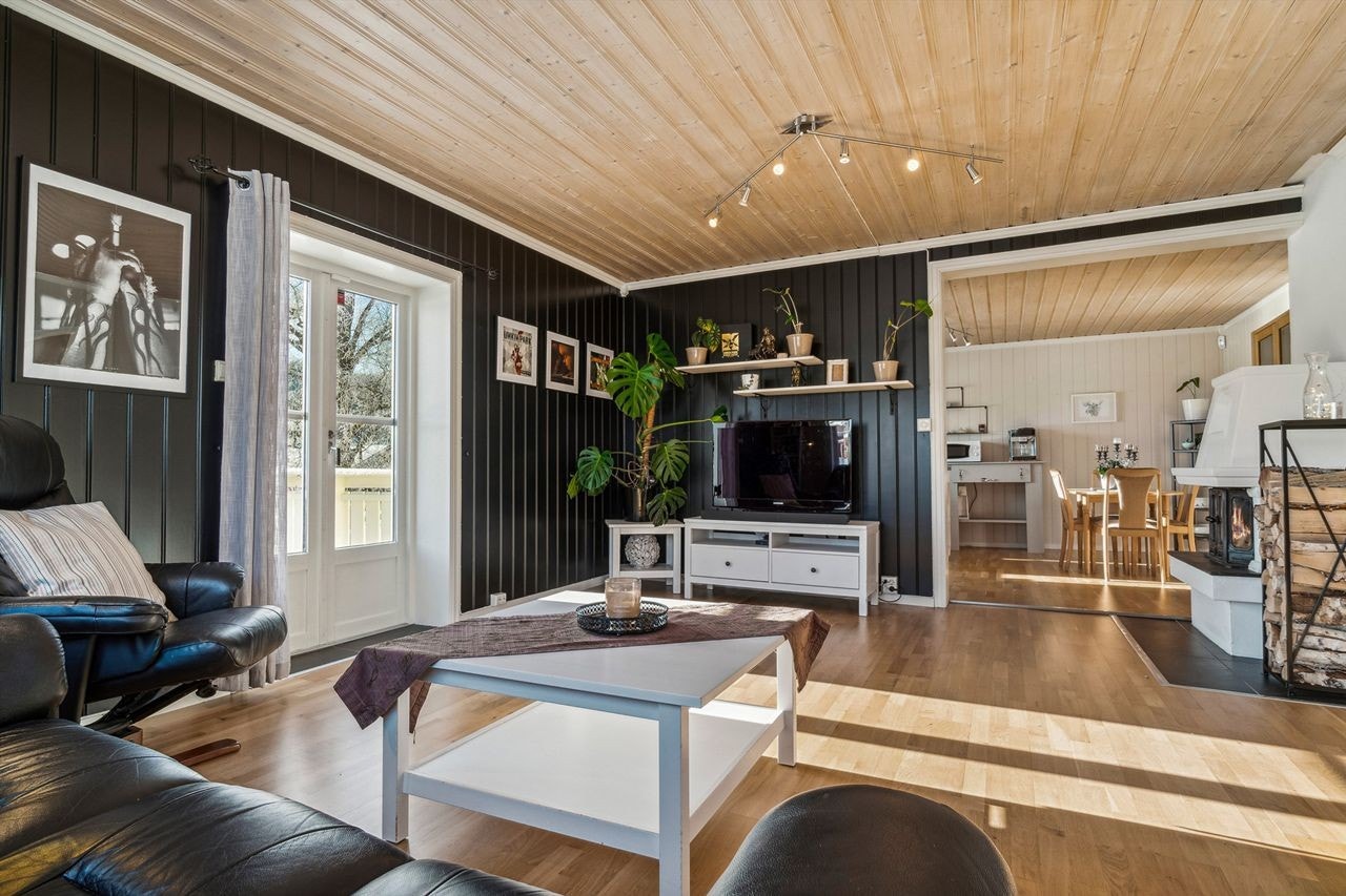 Dels åpen løsning mellom stue og kjøkken - sentralt plassert peis Galleribilde