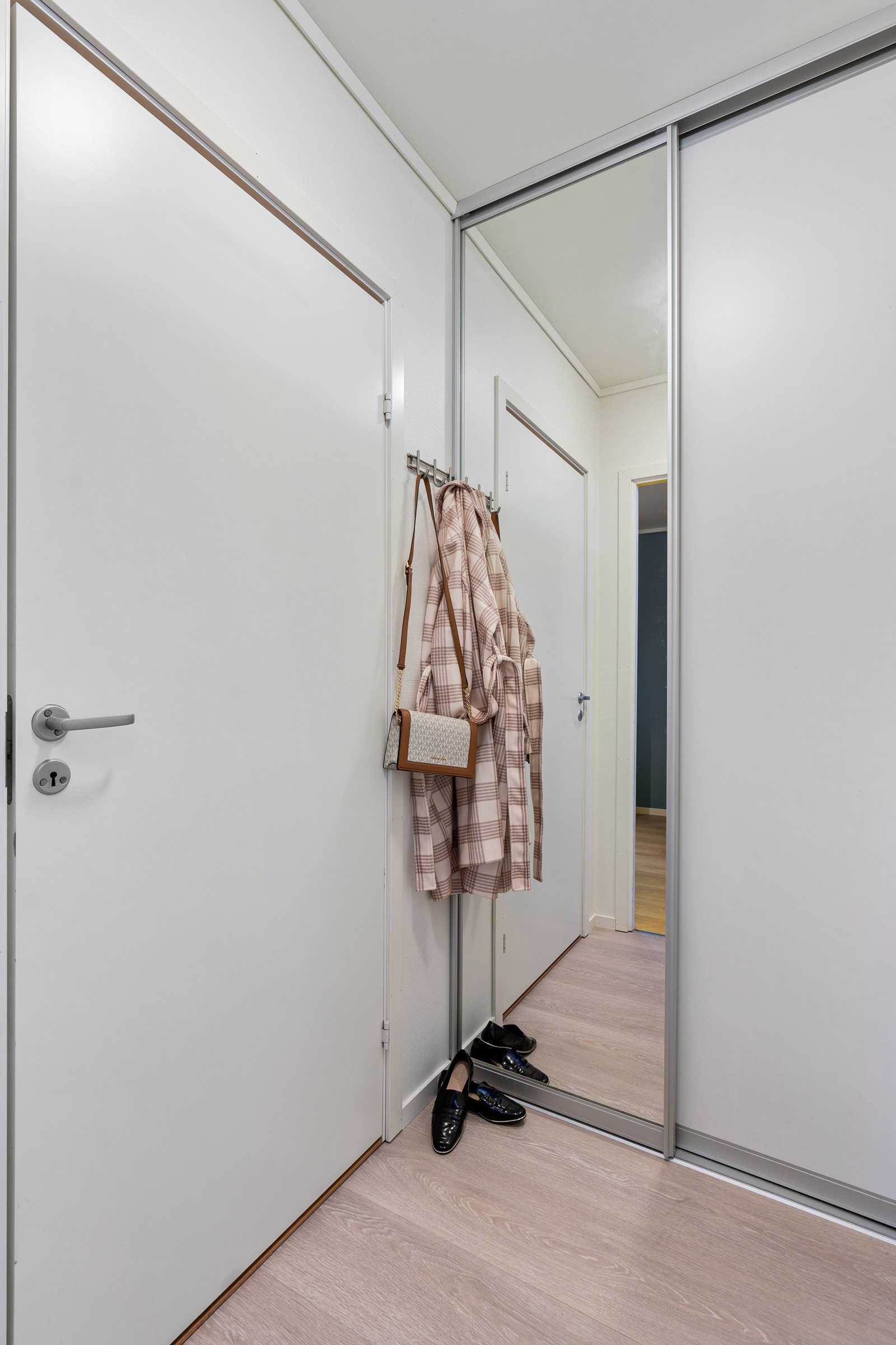 Skyvedørsgarderobe i gang til å henge fra seg yttertøyet.