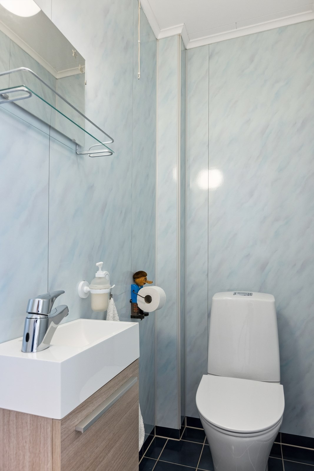 Separat WC. Innredet med gulvstående toalett fra 2020, liten servant m/underskap fra 2012, speil og lys. Galleribilde