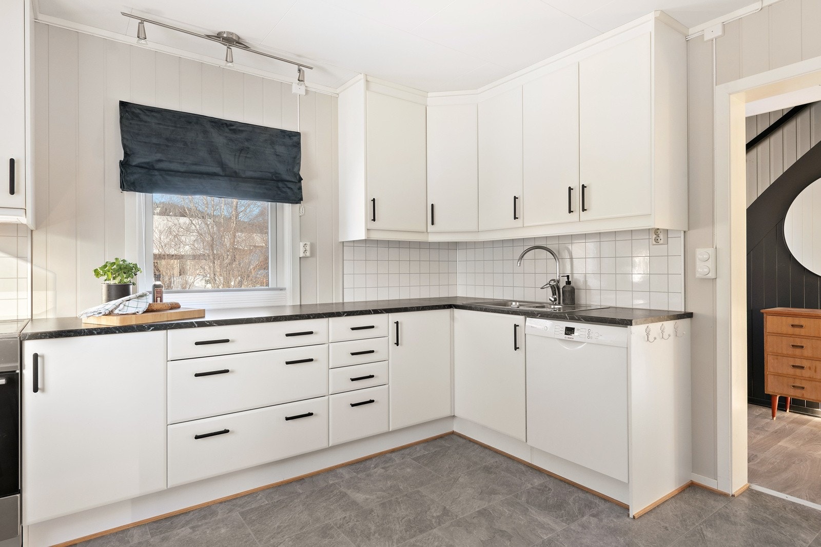 Kjøkkeninnredning og innvendige overflater er fra 2013. Slette, hvite fronter og laminerte benkeplater. Kjøkkenplater på vegger mellom benkeplater og overskap. Galleribilde