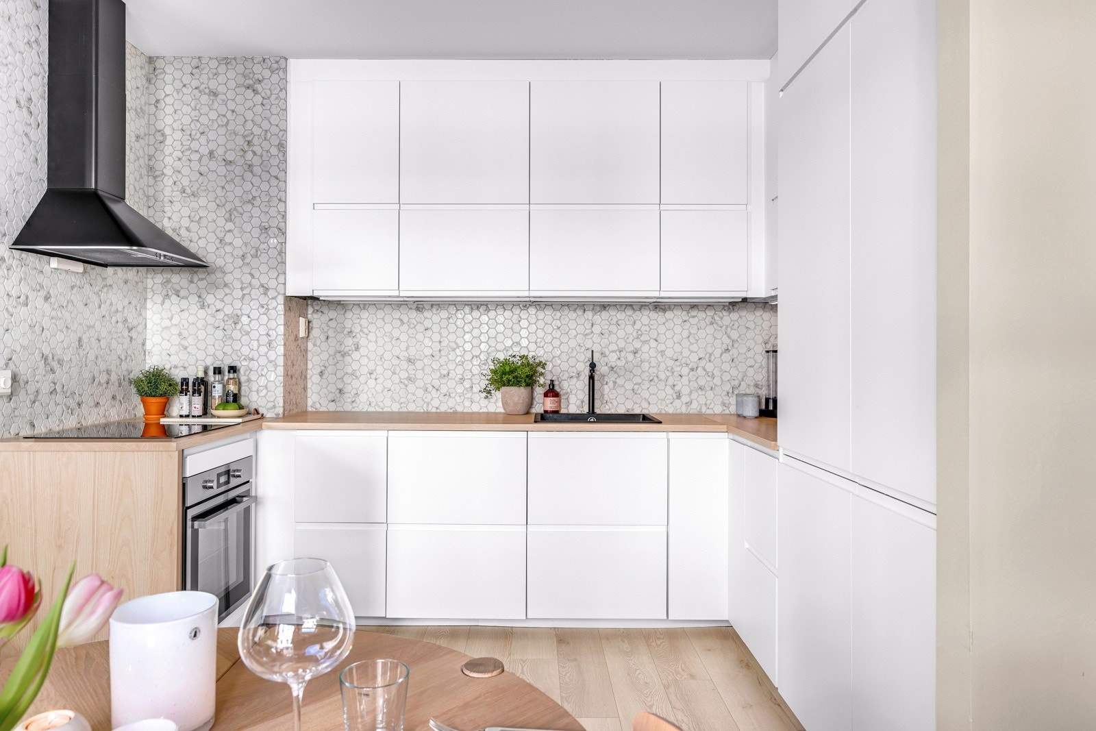 Kjøkkenet fra 2021 er utstyrt med hvit glatt kjøkkeninnredning, laminat benkeplate, fliser over benk, utslagsvask med ett-greps blandebatteri, kjøkkenventilator og oppvaskmaskin. Galleribilde