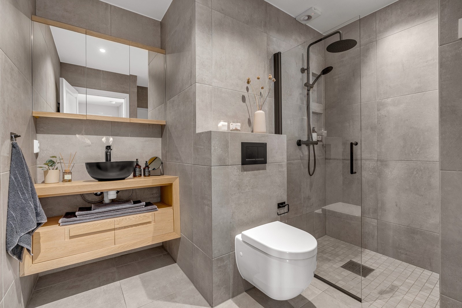 Det nyoppussede badet fra 2021 består av baderomsinnredning i eik med ovenpåliggende servant og ett-greps blandebatteri, speil, lys, dusjhjørne med glassdører og vegghengt toalett. Galleribilde