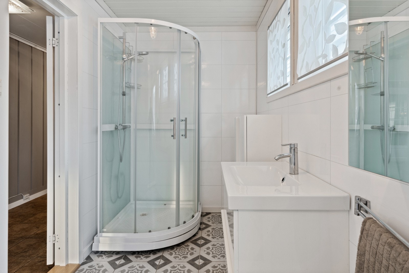 Pent bad med servantskap, dusjkabinett og skap. Fliser m/varme i gulv. Galleribilde