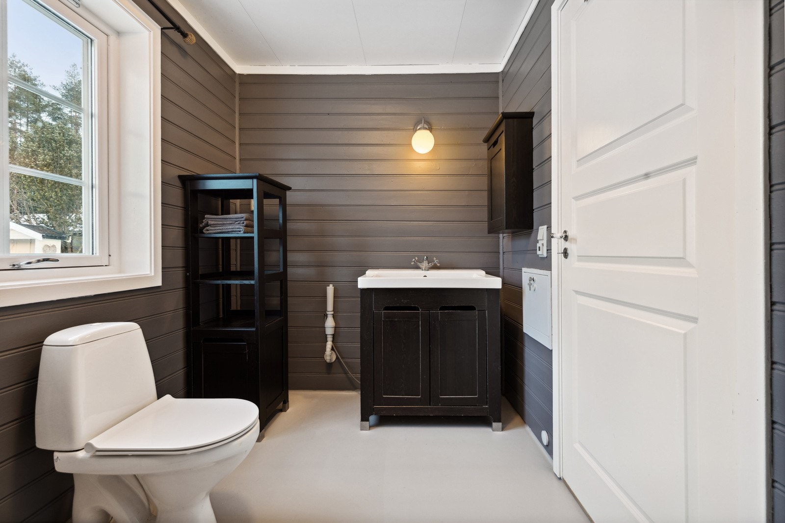 Romslig bad med panel på vegger og malt vinylbelegg på gulv. Galleribilde