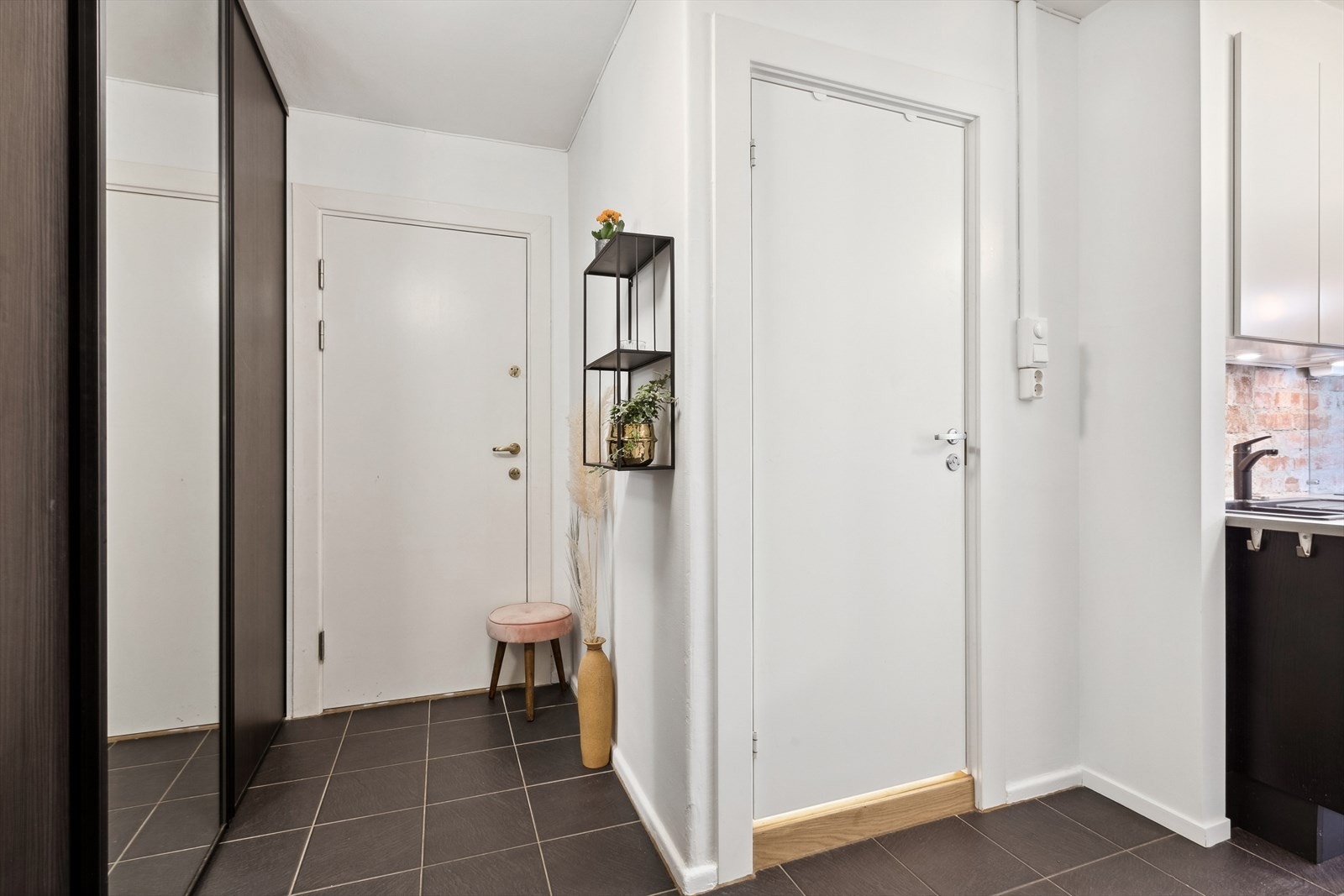 Fra felles inngangsparti er det adkomst til etasjeplan, og en innbydende, flislagt entré ønsker deg velkommen inn. Det er god plass for yttertøy og sko i romslige garderobeskap. Galleribilde