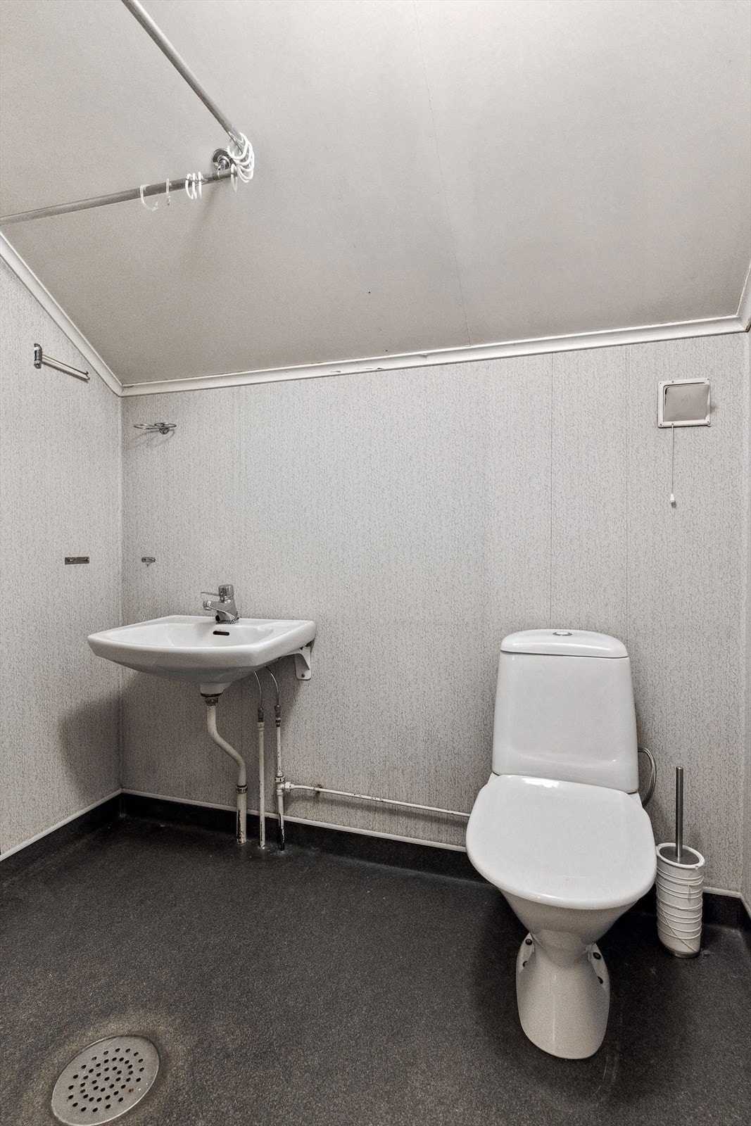 Badet i loftsetasjen er fra byggeår. Det har nylig vært en lekkasje på badet da dette ikke er tett. Det må derfor påregnes totalrenovering av badet. Enkelt bad bestående av klosett, servant og dusj m/foreng. Galleribilde