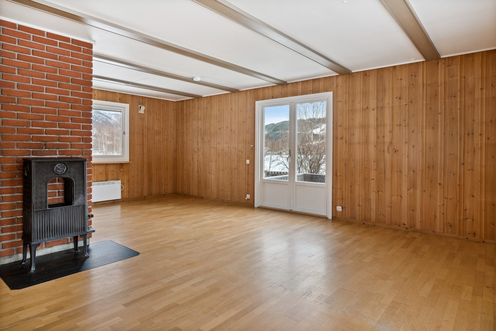 Stuen er tilknyttet en vedovn for oppvarming. Galleribilde