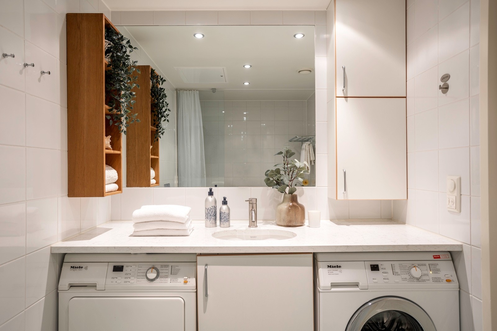 Innredningen har benkeplate i Silestone komposittstein og servant fra 2019, flere skap og hyller til praktisk lagring. Badet har også praktisk opplegg for vaskemaskin og tørketrommel, som medfølger Galleribilde
