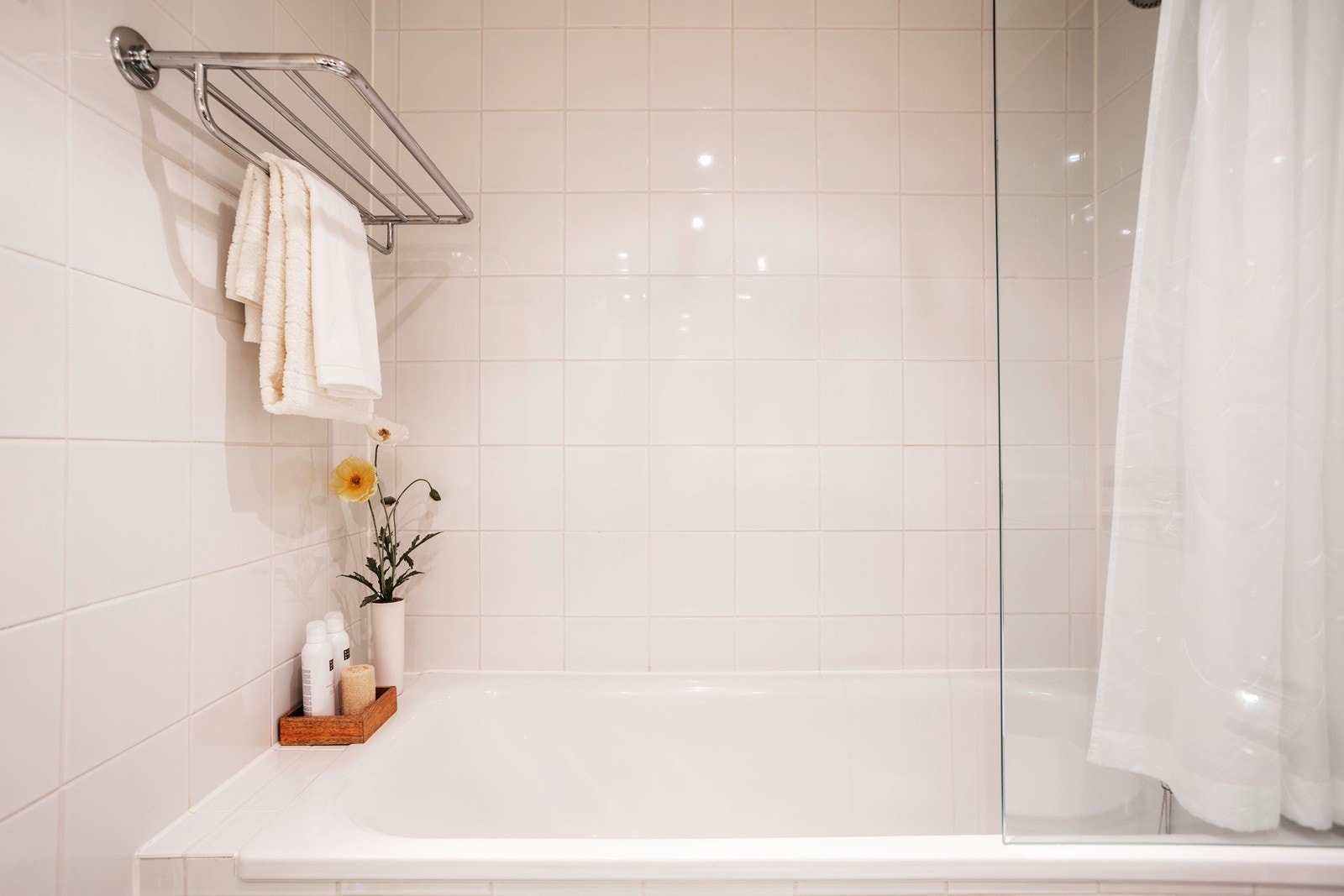 Videre har badet vegghengt klosett, innmurt badekar med veggmontert armatur, garnityr og dusjvegg i glass Galleribilde