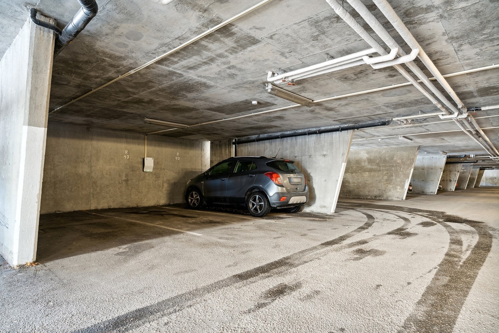 Medfølgende parkeringsplass med elbil-lader i felles garasjeanlegg, beliggende kun 2 min. gange fra boligen. Galleribilde