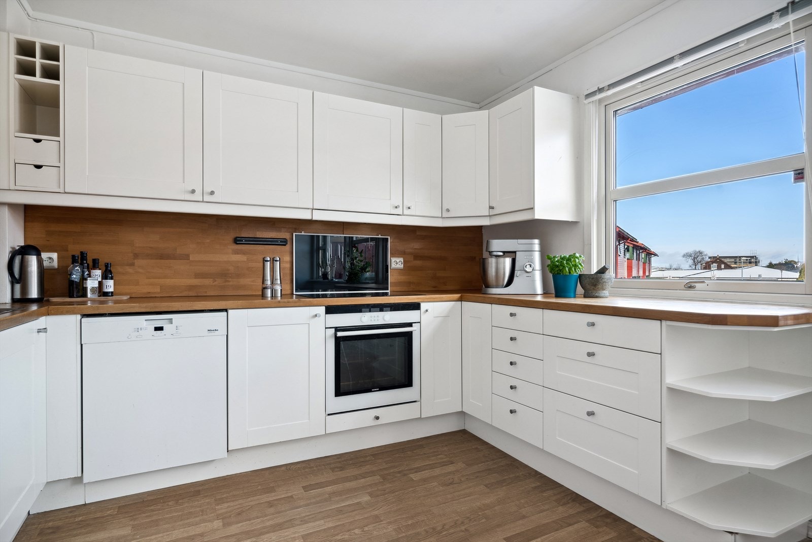 Kjøkkeninnredning fra IKEA med hvite, profilerte fronter og heltre benkeplate. Galleribilde