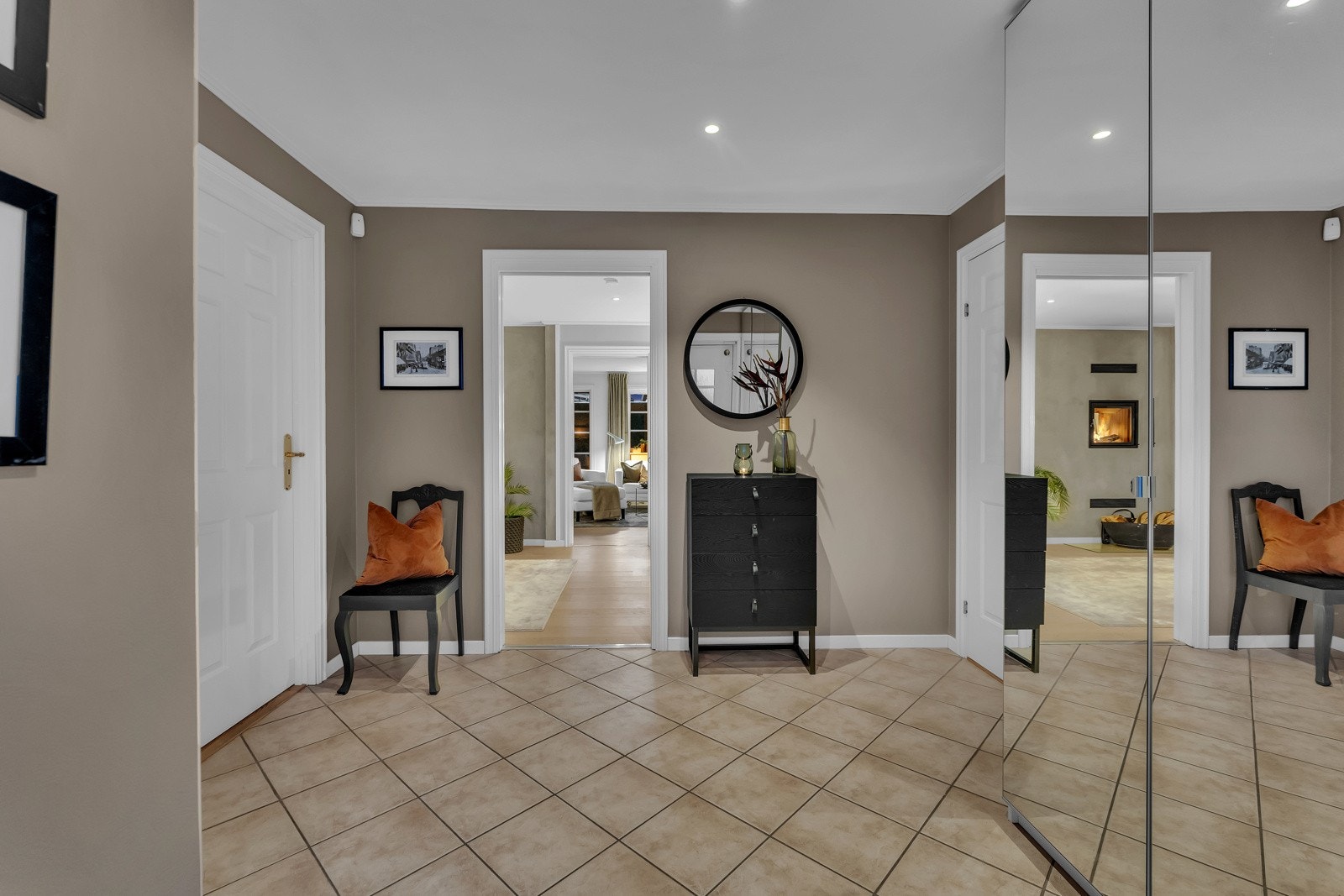 Hallen er innbydende og romslig. Den har flislagte gulv og er malt i en dus tone. Til oppbevaring av familiens yttertøy og sko, har hallen en stor og romslig garderobe med speildører. Galleribilde