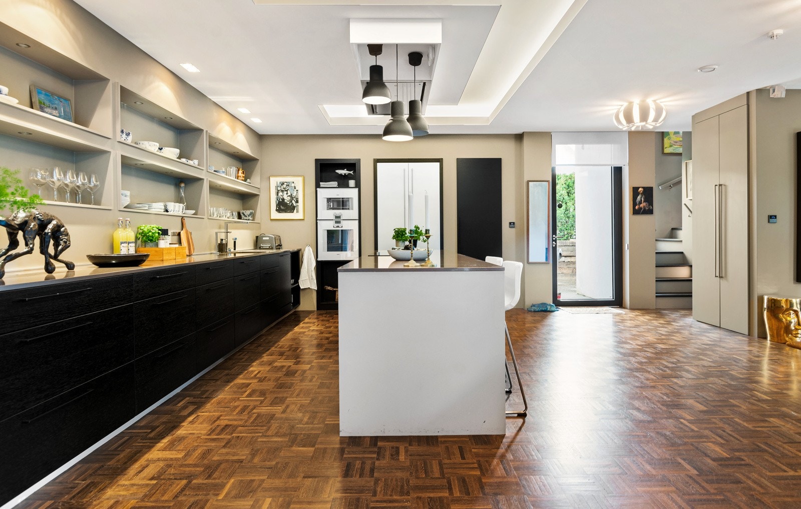 Alle hvitevarer er integrert, og består av Gaggenau stekeovn og dampovn i fin arbeidshøyde. Videre er det 80 cm bred induksjonstopp og ventilator montert i himlingen over kokesonen. Dessuten er det oppvaskmaskin og et kombinert Gaggenau kjøl/frys. Galleribilde