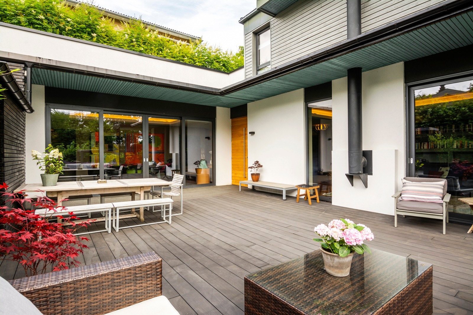 Høyreiste levegger, skjermende beplantninger og gesimser skaper nærmest en atriumshage. Galleribilde