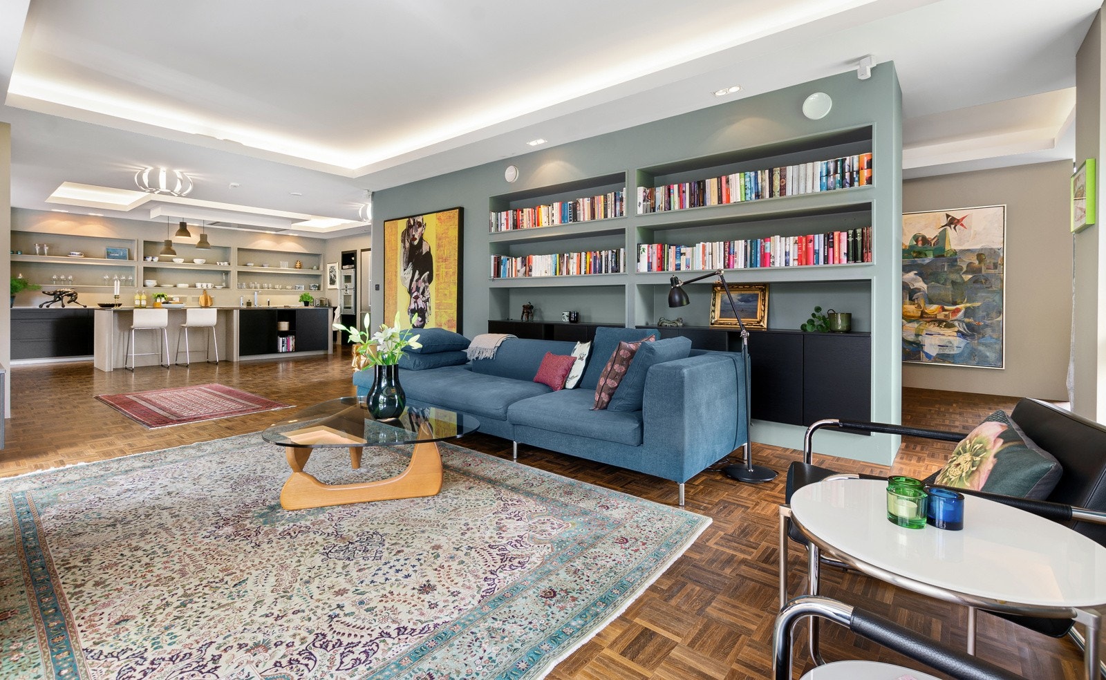 Stuen har en bred vegg med fastmonterte bokhyller og plassbygde skap. Galleribilde