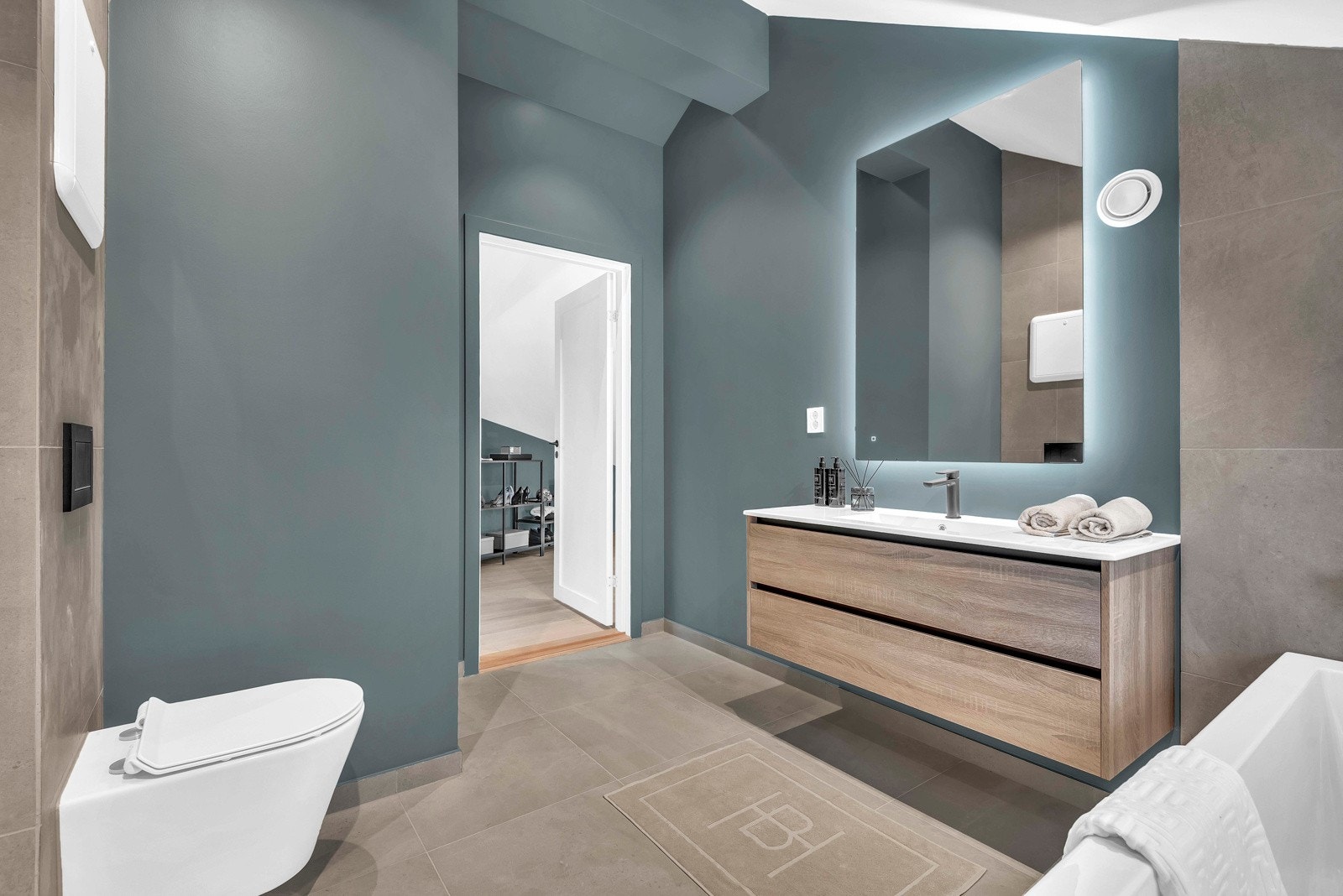 Badet er utstyrt med badekar, dusjhjørne, servant og vegghengt toalett. Galleribilde