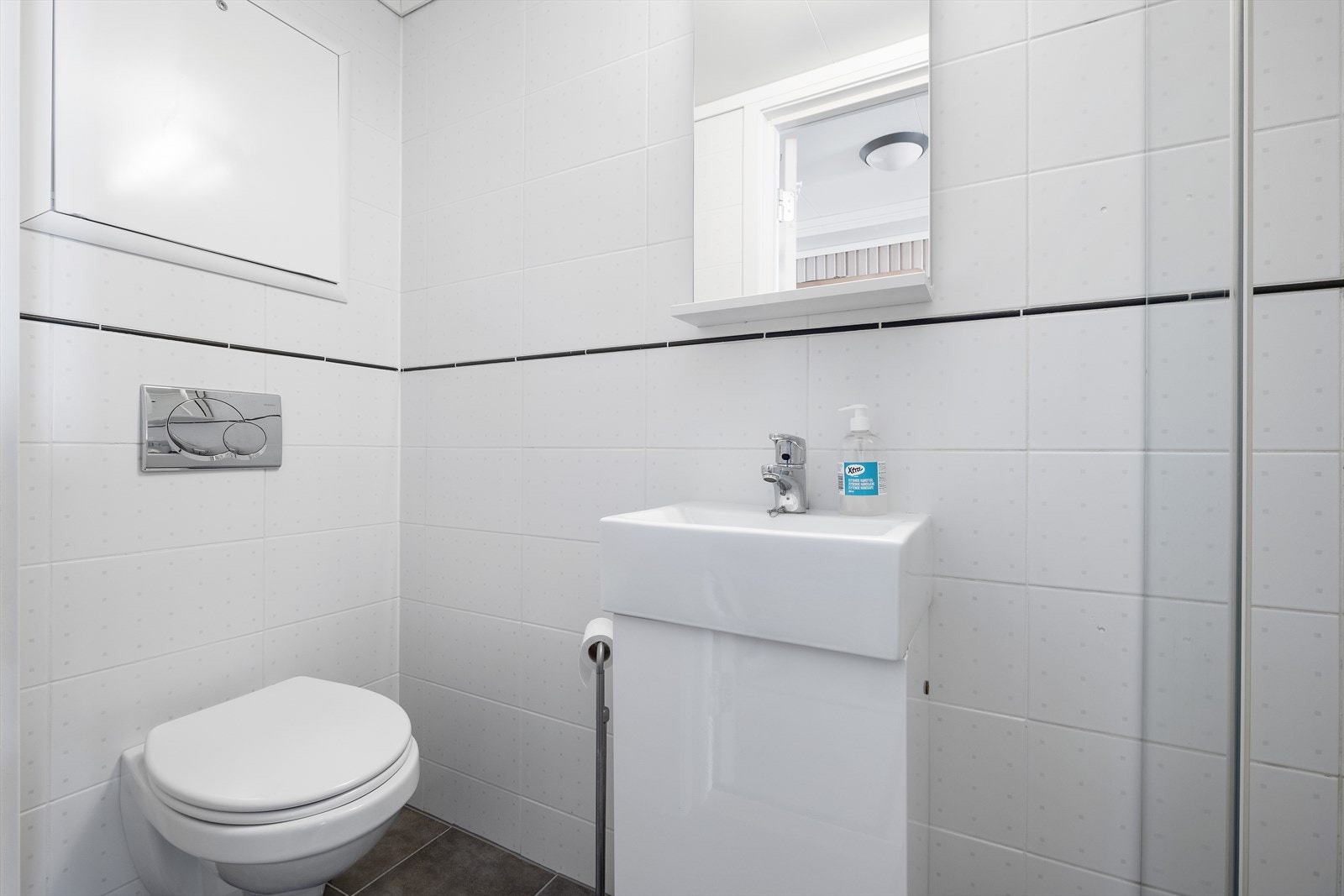 Badet inneholder vegghengt toalett, servant med underskap og dusj Galleribilde