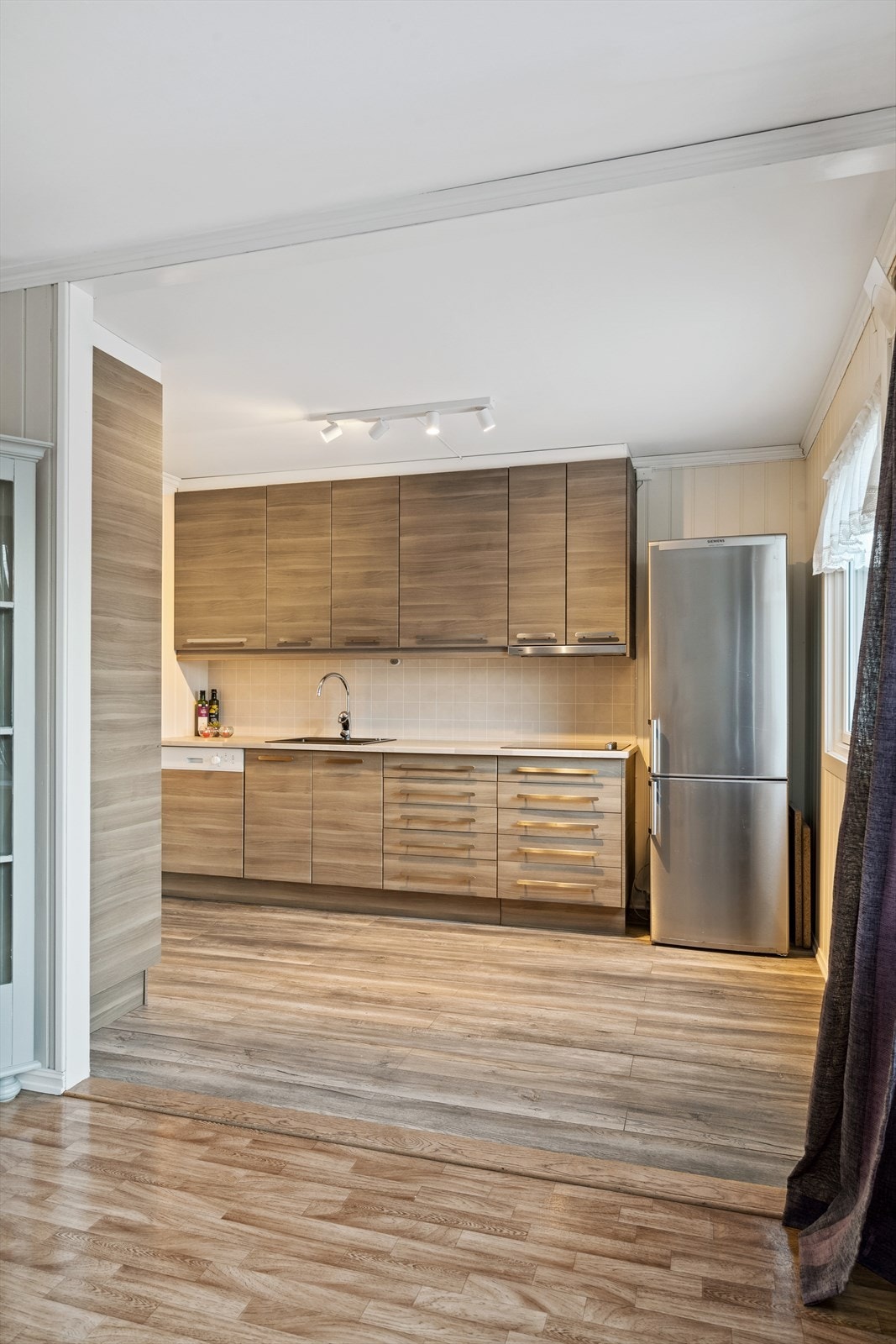 Det er åpen løsning mellom stuen og kjøkkenet. Galleribilde