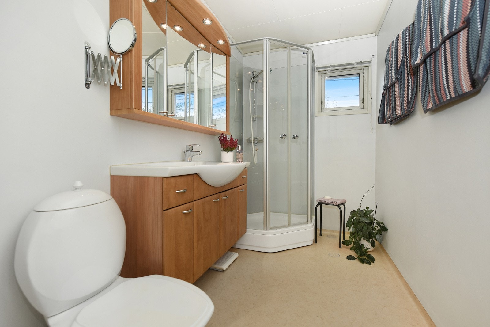 Rommet er innredet med wc, dusjkabinett, servantskap og speilskap. Galleribilde