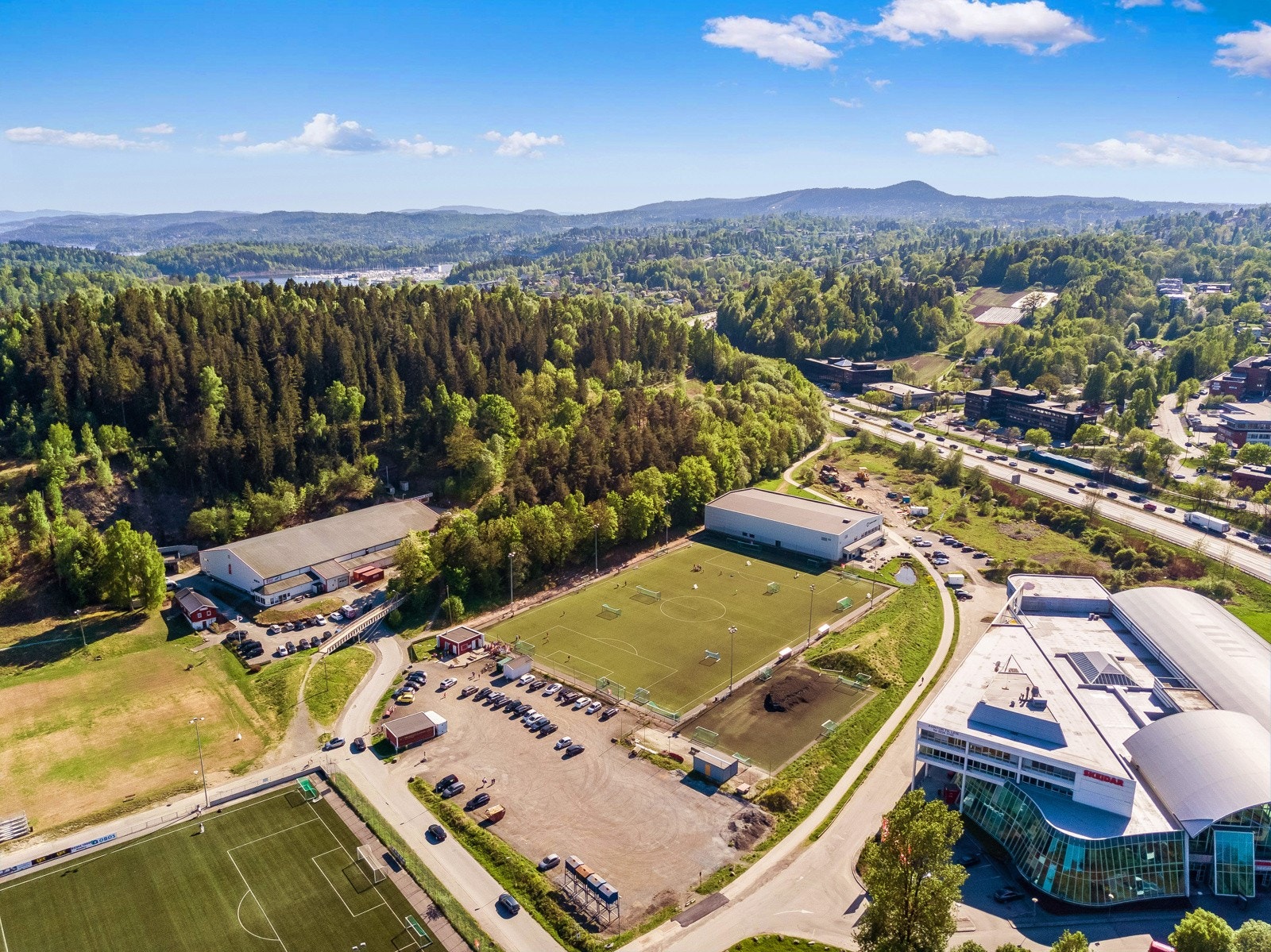 Holmen idrettspark med flere fotballbaner, klatrevegg, ishall, turnhall, tennisanlegg og lysløyper. Galleribilde