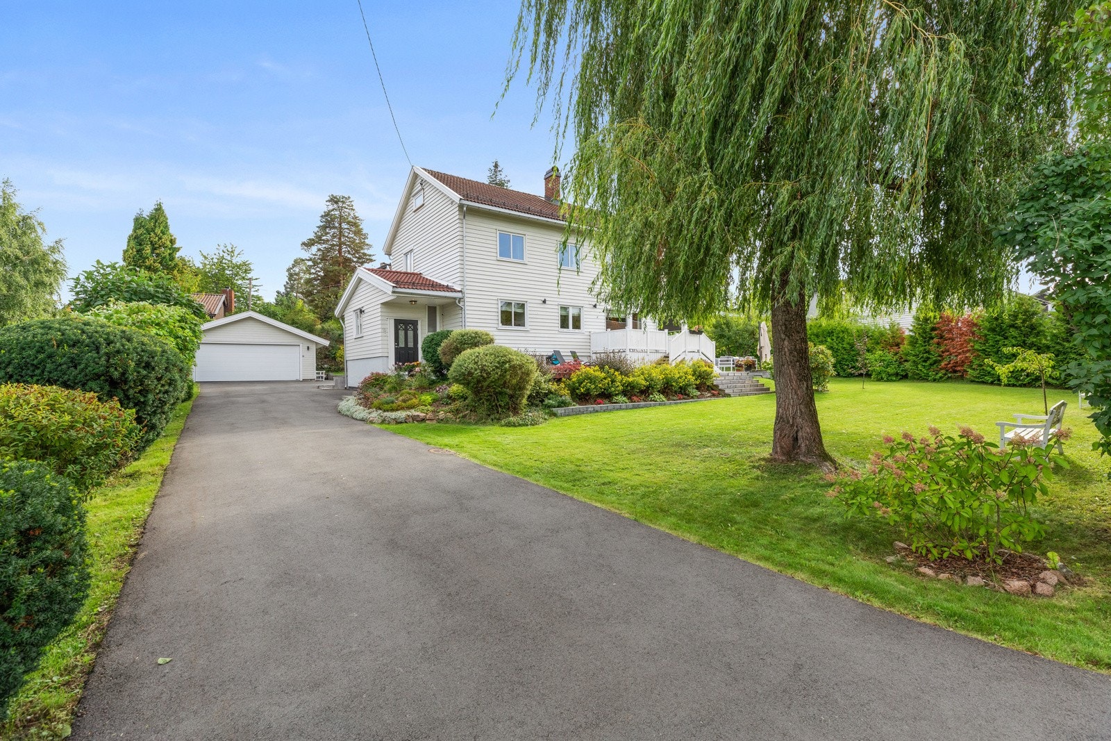 Stor gårdsplass med flere biloppstillingsplasser og dobbelgarasje fra 2017 med romslig bod og elbillader. Innkjøring og gårdsplass ble asfaltert i 2020. Galleribilde