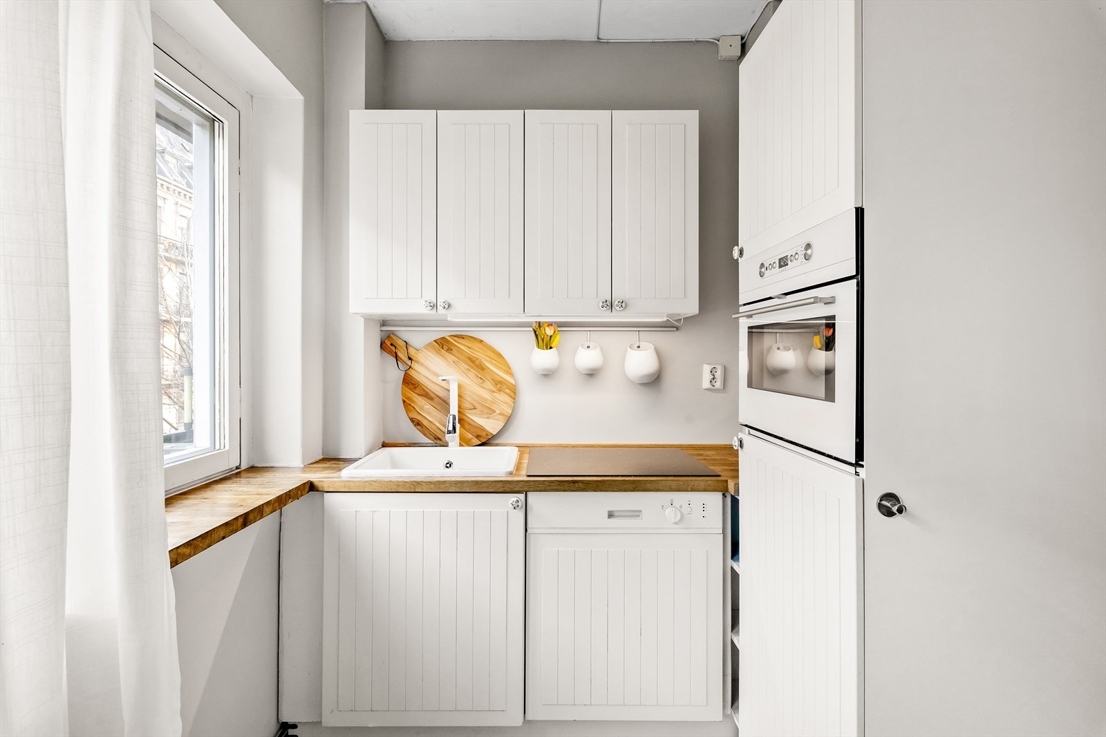 Kjøkken fra 2011 med integrerte hvitevarer som kjøleskap, kombi stek/mikro, oppvaskmaskin og platetopp. Galleribilde