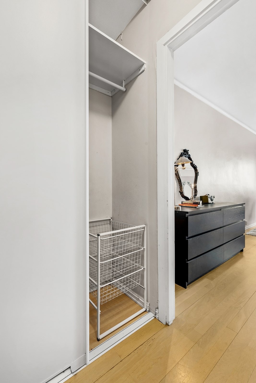 Lys gang med plassbygget skyvedørsgarderobe som går helt opp til taket. Galleribilde