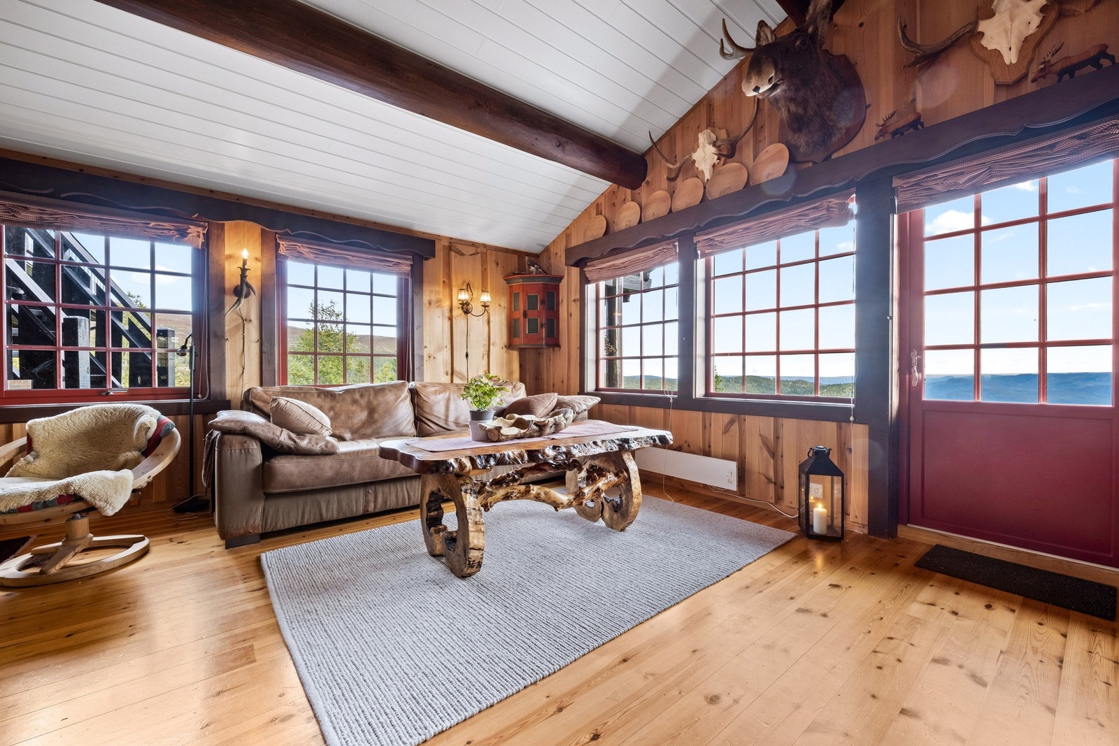 Utgang fra stuen til stor solrik terrasse med flott kveldssol og utsikt. Galleribilde