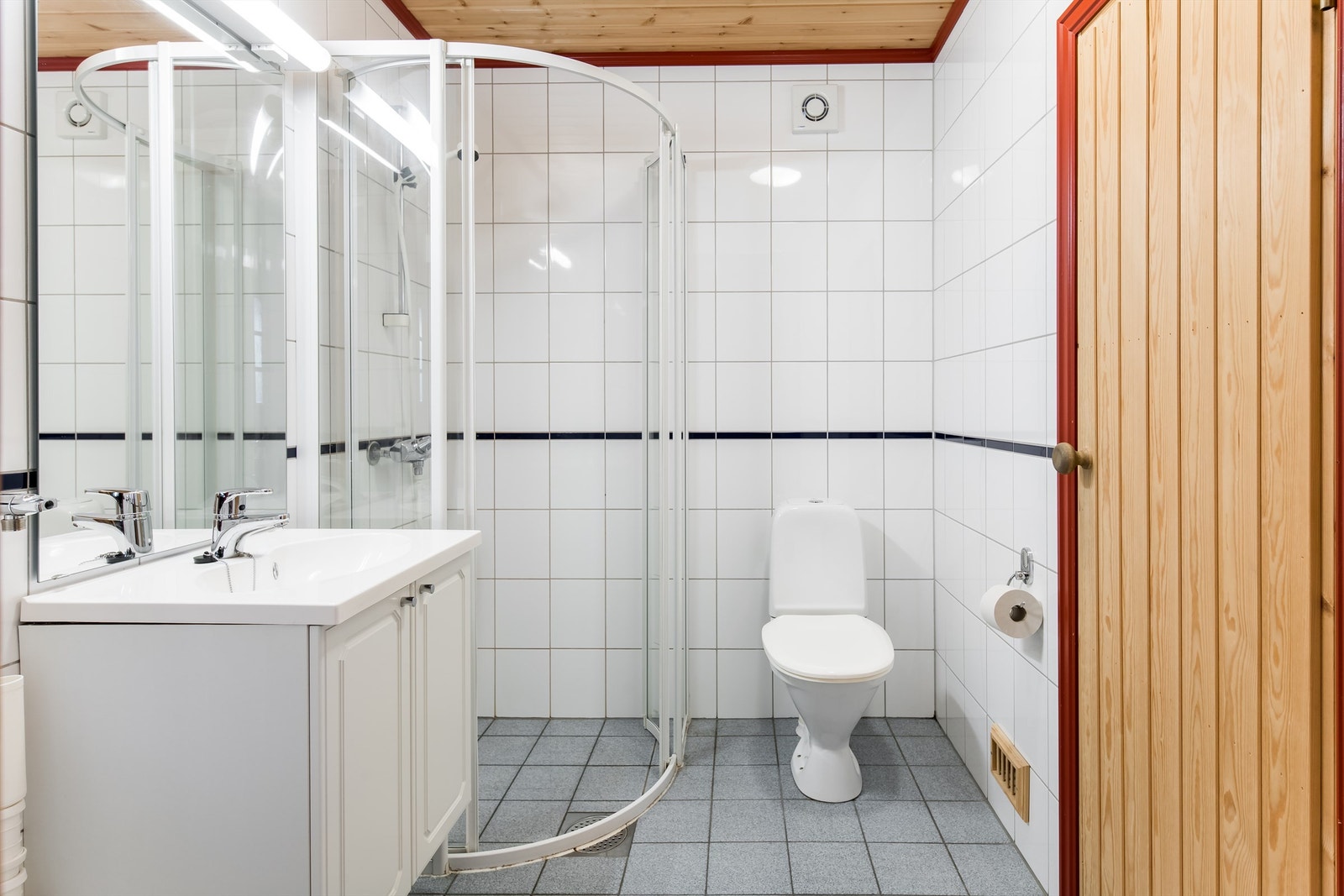 Flislagt bad med adkomst til badstue og opplegg for vaskemaskin. Dusjhjørne, wc og innredning med servant Galleribilde