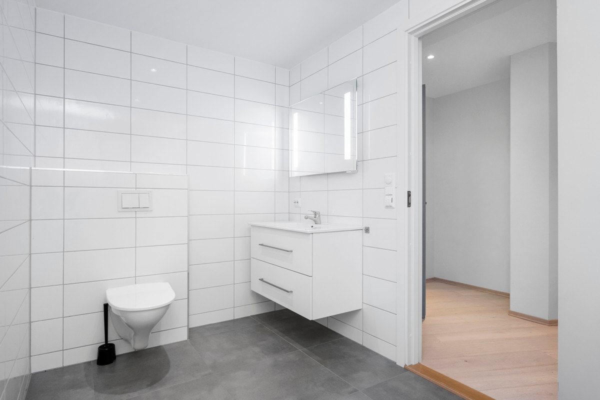 Flislagt bad med servant, wc og dusj på gulv Galleribilde