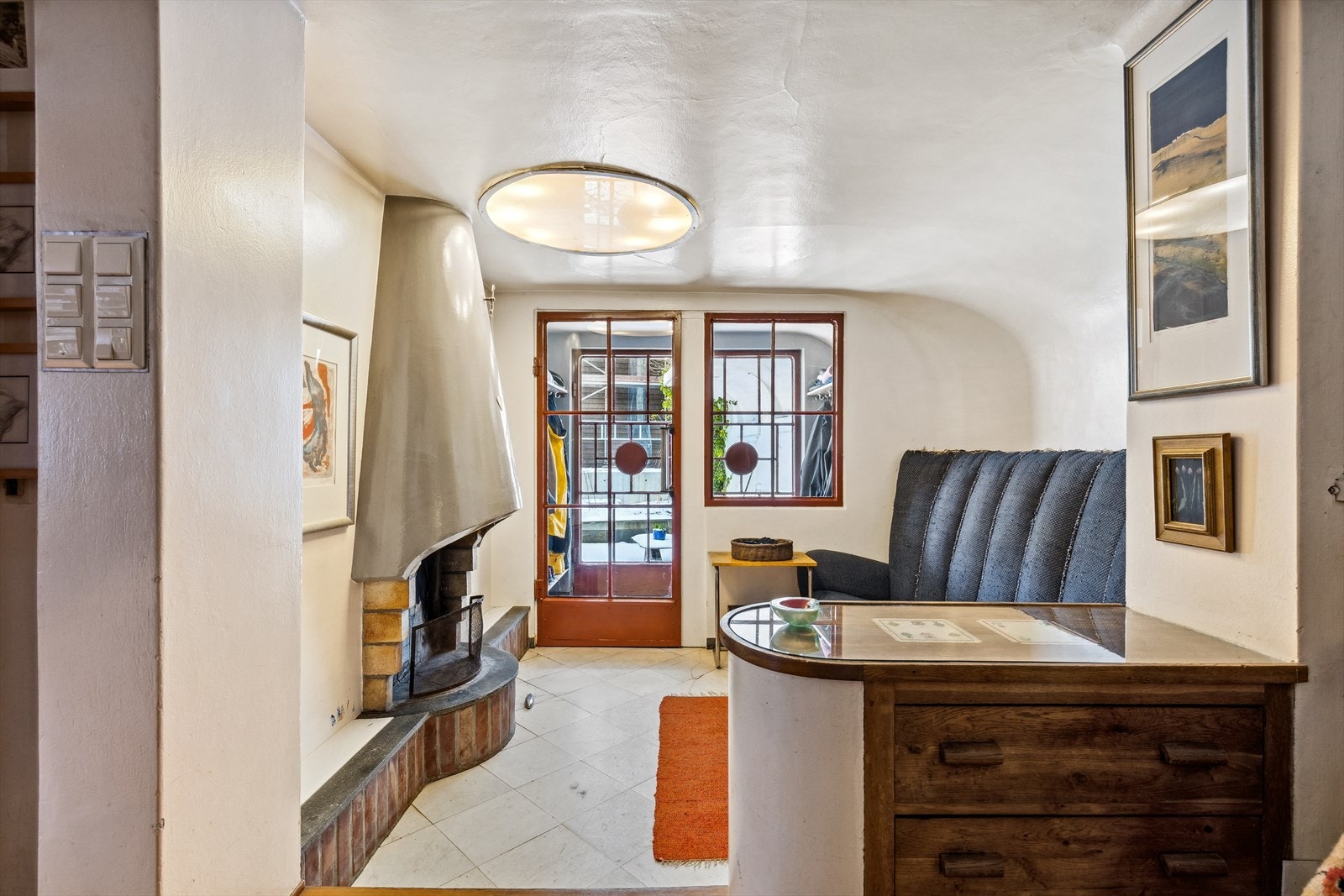 Videre via glassdør kommer du inn en hyggelig forstue med åpen peis og fliser på gulvet. Galleribilde