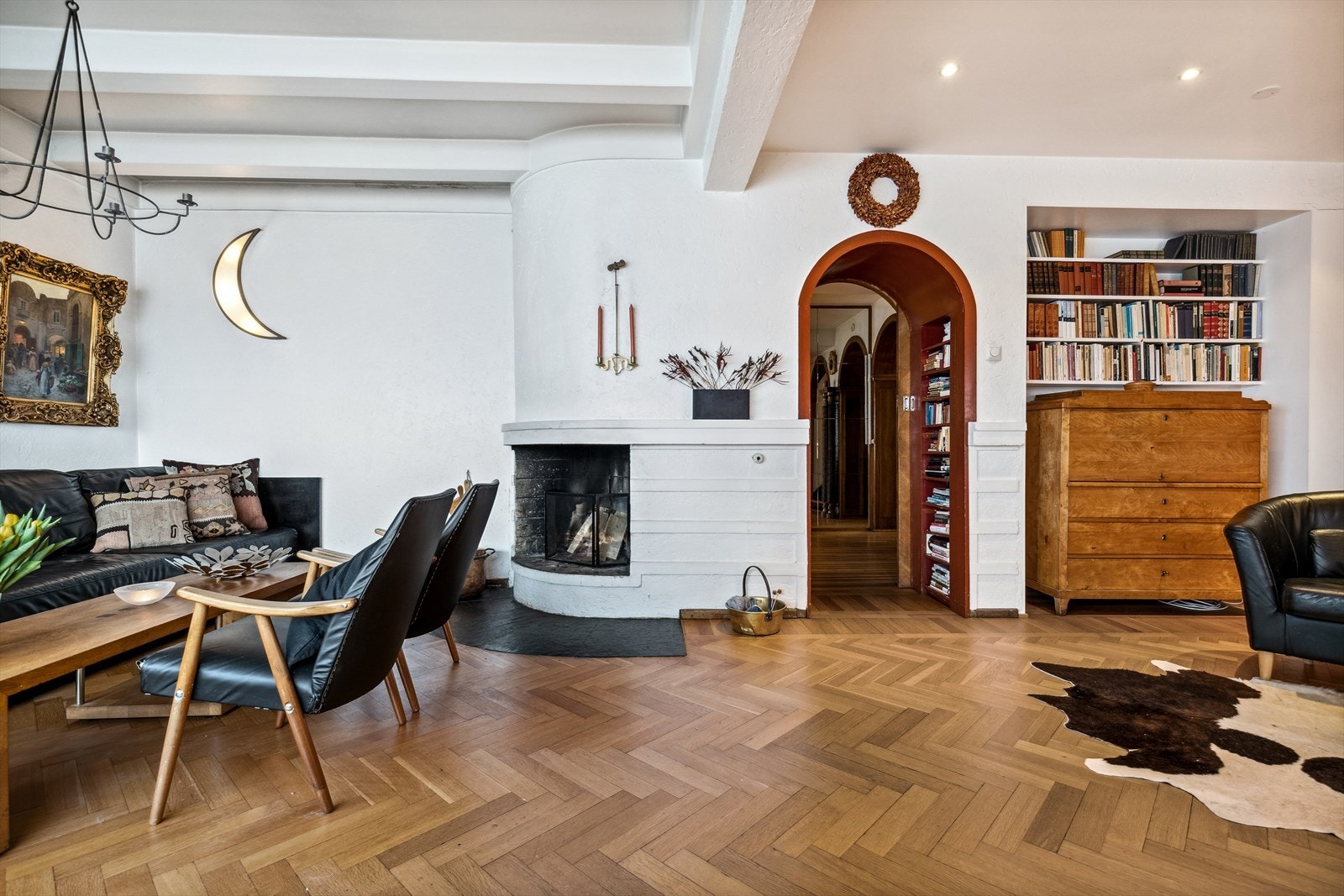 Stue med synlige takbjelker og original åpen peisovn. Galleribilde