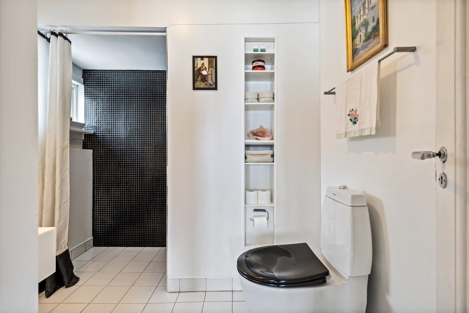 Baderommet har dusjnisje, gulvmontert toalett og servant i nisje. Galleribilde